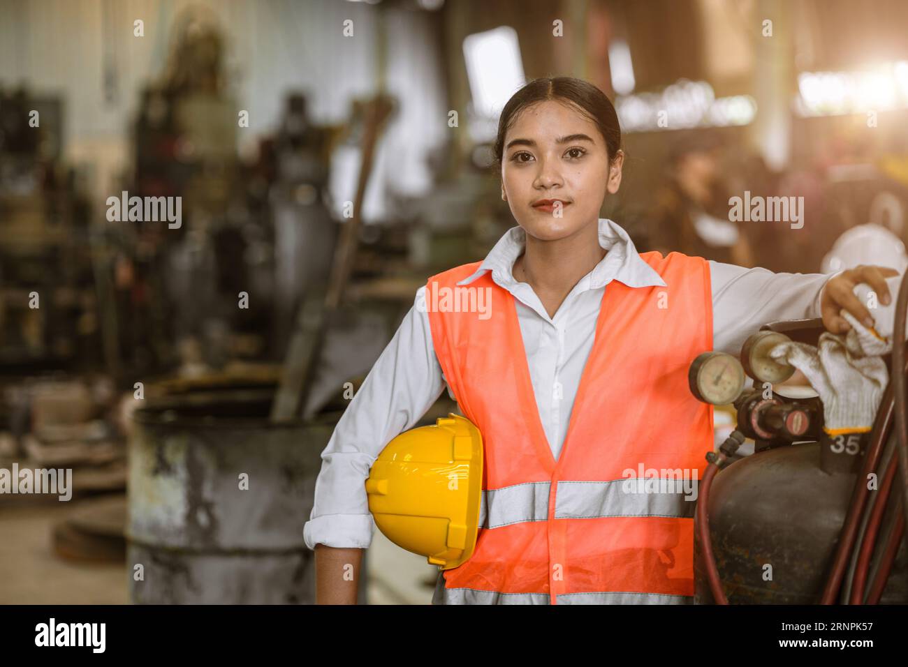 portrait heureuse jeune femme asiatique travailleuse avec l'industrie d'usine de fraisage de tour de machine de métal lourd Banque D'Images