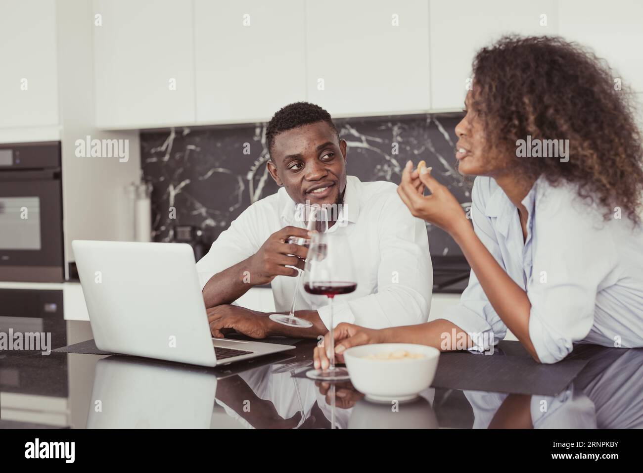 Les gens noirs couple boire du vin dates parler ensemble se détendre réunion dans la cuisine maison de couleur vintage ton Banque D'Images