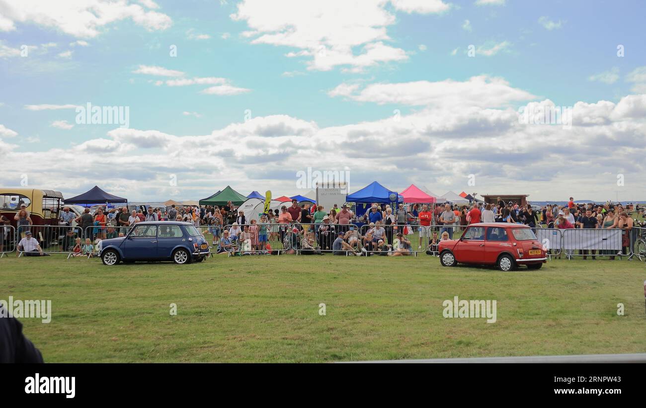 Deux Austin Minis vintage tournant dans une arène. Le rallye de voitures de Gosport est organisé par le Rotary Club local et a lieu à Stokes Bay le lundi jour férié du mois d'août. L'événement de cette année, offrant une journée en famille bon marché, était le soixante-dixième et a accueilli des voitures et des motos anciennes, une ferme pour enfants, des stands, des rafraîchissements et une arène qui a fourni diverses formes de divertissement. Banque D'Images