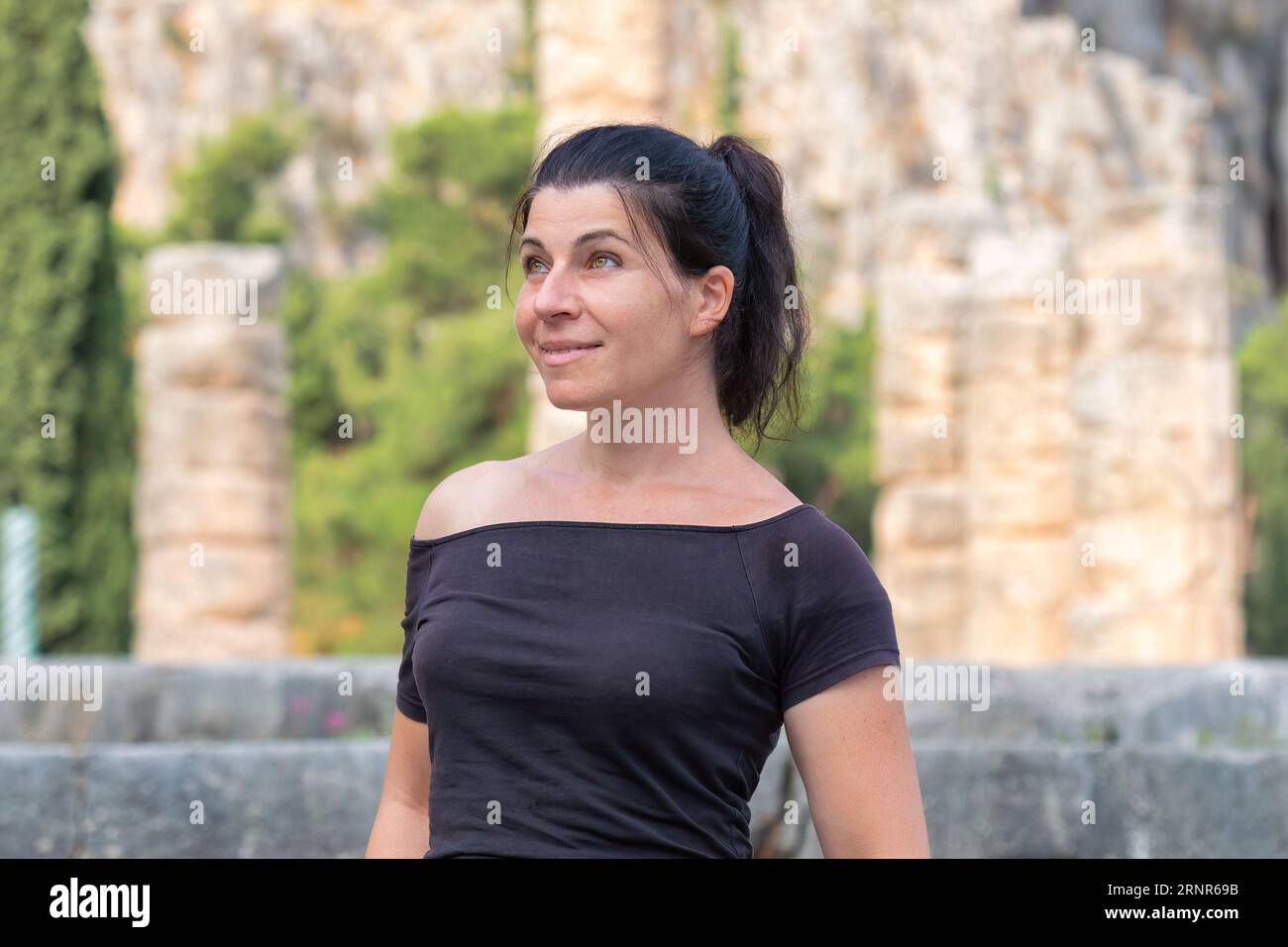 Portrait d'une femme contre les ruines antiques de Delphes en Grèce. Banque D'Images