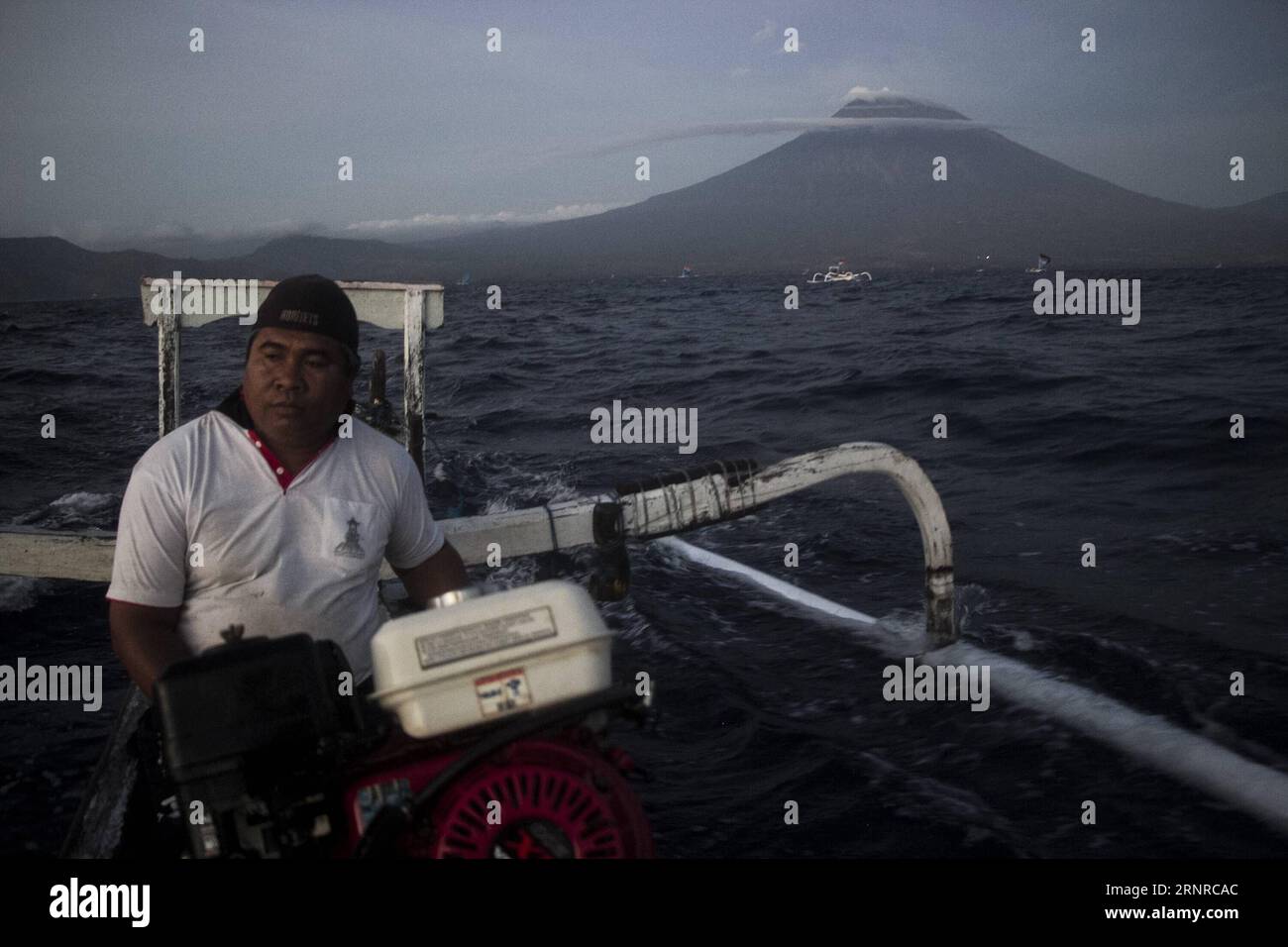 (170926) -- BALI, 26 septembre 2017 -- Un pêcheur avec son bateau est vu près du Gunung Agung, ou volcan du mont Agung, sur la plage d'Amed dans le Karangasem regency, Bali, Indonésie. 26 septembre 2017. Le nombre de personnes évacuées a augmenté à plus de 57 000 que le volcan Gunung Agung dans l'île de Bali est potentiel pour entrer en éruption, un haut responsable de l'agence de catastrophe a déclaré mardi. (gj) INDONÉSIE-BALI-MONT AGUNG M.xFauzixChaniago PUBLICATIONxNOTxINxCHN Banque D'Images