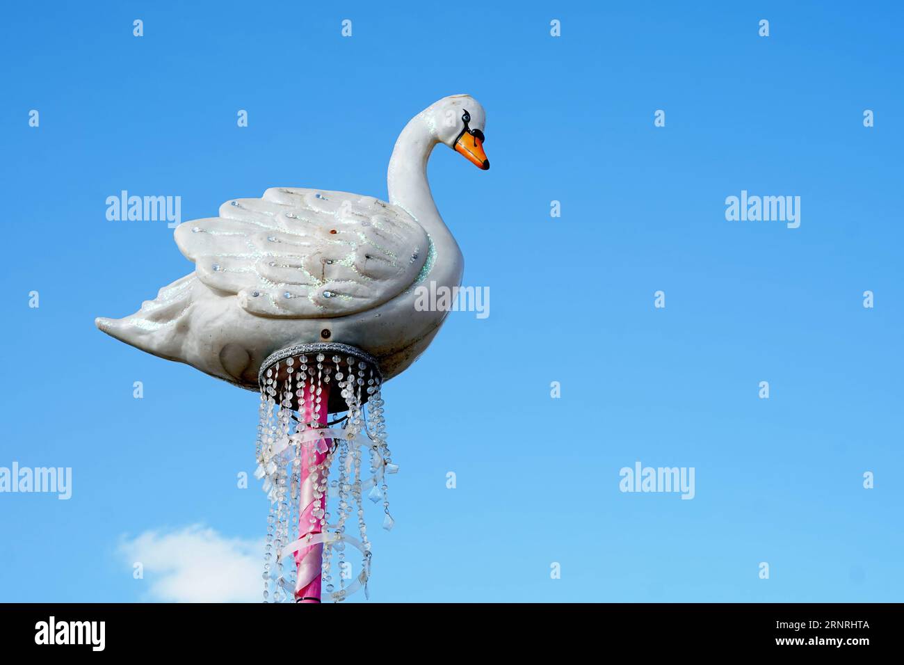 Cygne décoratif blanc sur un poteau contre un ciel bleu clair d'été Banque D'Images