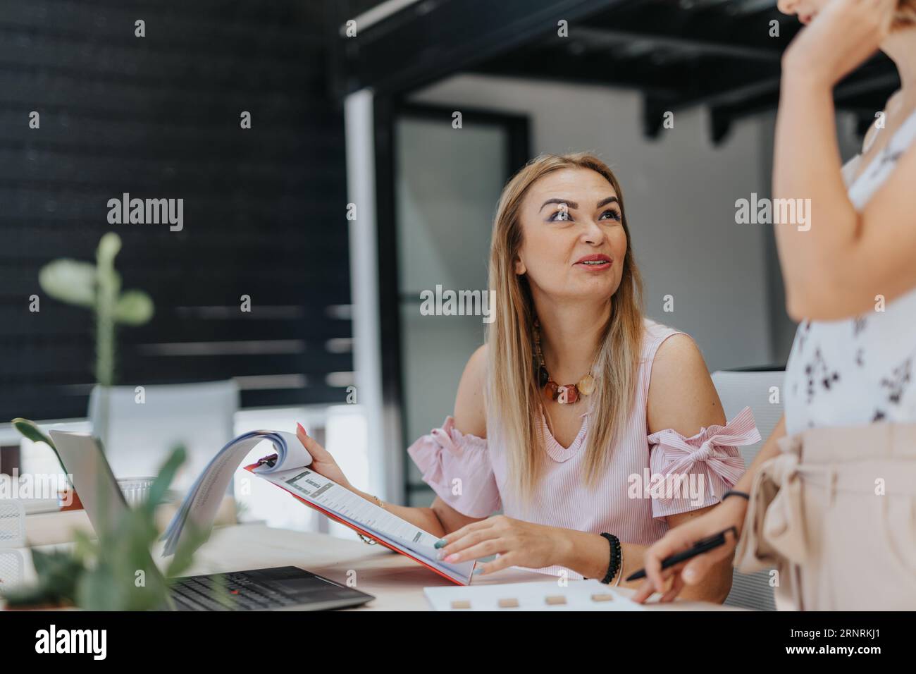 Heureuse, satisfaite, femme d'affaires senior lisant et analysant le travail de son collègue, des résultats positifs ou des réalisations. Banque D'Images