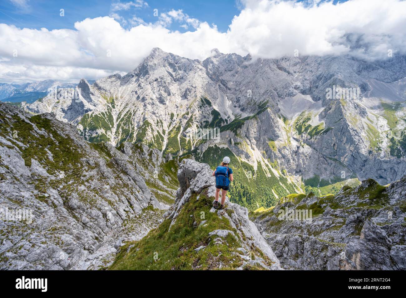 Alpiniste grimpant Waxenstein, Alpspitze Wetterstein en arrière-plan, Garmisch-Patenkirchen, Bavière, Allemagne Banque D'Images