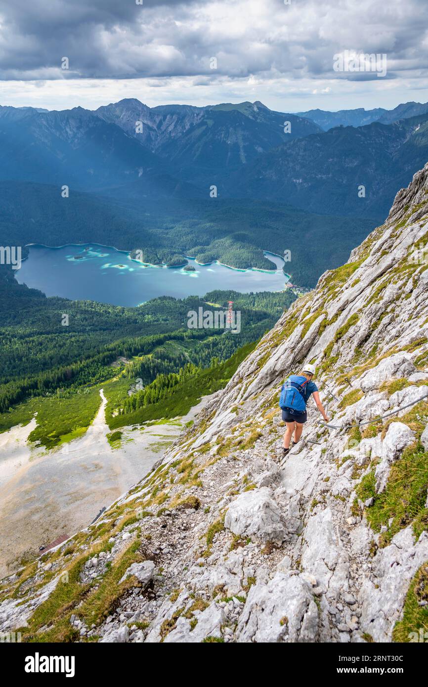 Via ferrata sur la Riffelscharte, randonneur dans les montagnes, vue sur le lac Eibsee et Werdenfelser Land, montagnes Wetterstein, Garmisch-Patenkirchen, B. Banque D'Images