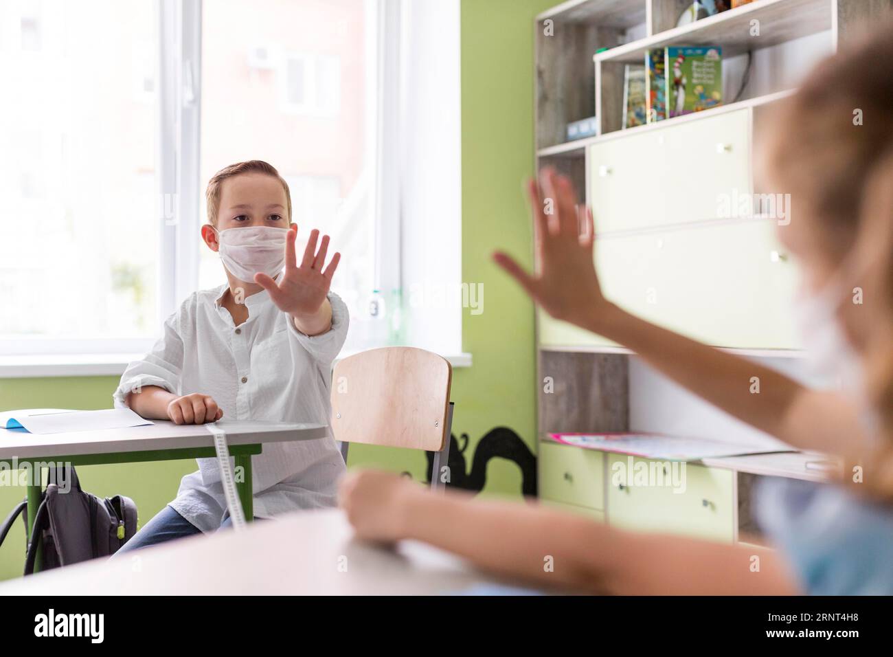 Enfants agitant la salle de classe tout en gardant la distance sociale Banque D'Images