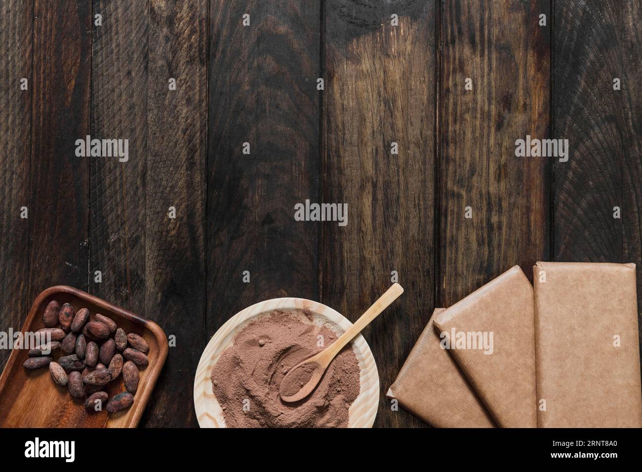 Fèves de cacao en poudre avec table en bois enveloppée de barre de chocolat Banque D'Images