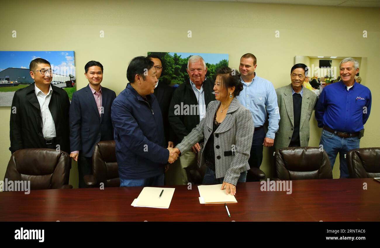 (171103) -- KENTUCKY (États-Unis), 3 novembre 2017 -- l'entrepreneure chinoise Angie Yu (à droite, devant) de Two Rivers Fisheries serre la main d'un représentant de Jiangsu Rentian Agricultural Technology Co. Ltd de Chine après avoir signé un accord au Kentucky, aux États-Unis, le 30 octobre 2017. L'entrepreneure chinoise Angie Yu est venue à la ville de Wickliffe dans l'ouest du Kentucky et a ouvert les Two Rivers Fisheries pour transformer le poisson du Mississippi en 2012. Two Rivers Fisheries emploie maintenant 16 résidents locaux qui effectuent des travaux de transformation en usine et achète régulièrement du poisson à plus de 70 pêcheurs à proximité. La prod Banque D'Images