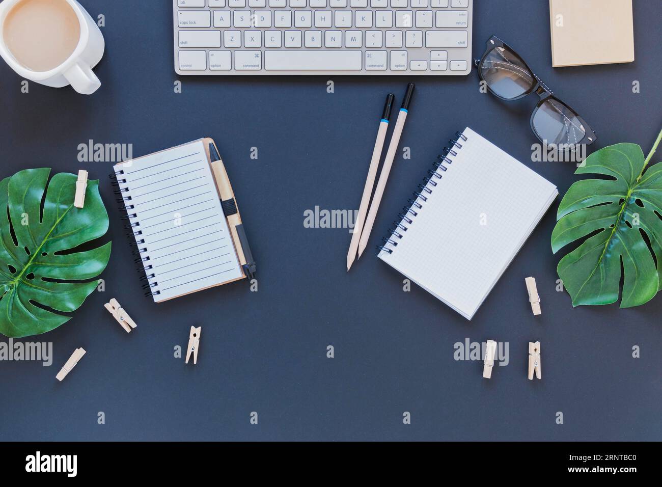 Papeterie près de la table de tasse de café de clavier avec des feuilles Banque D'Images