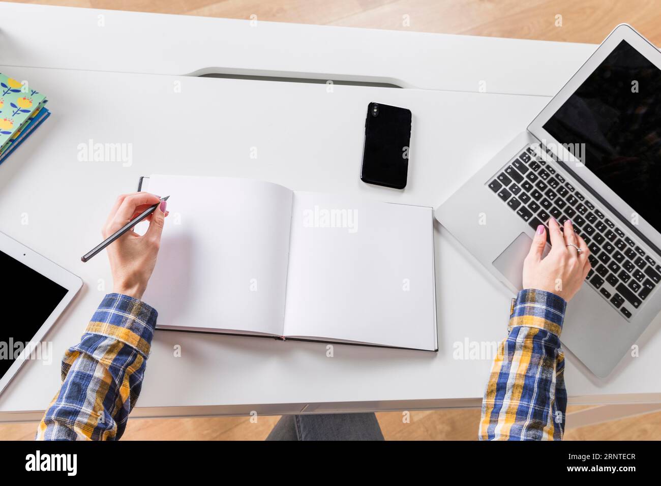 Mains femme écrivant le cahier touchant le clavier ordinateur portable Banque D'Images
