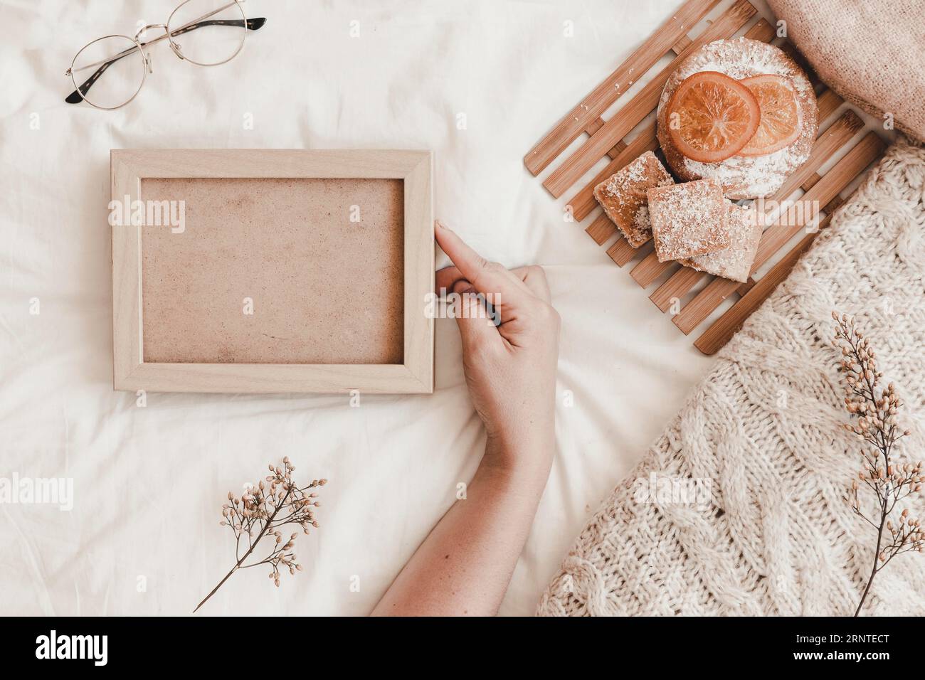 Main touchant le cadre près du lit de pâtisserie Banque D'Images