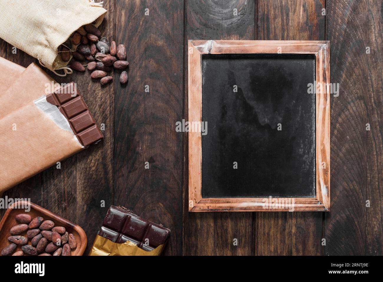 Ardoise en bois vierge avec des barres de chocolat de fèves de cacao table en bois Banque D'Images