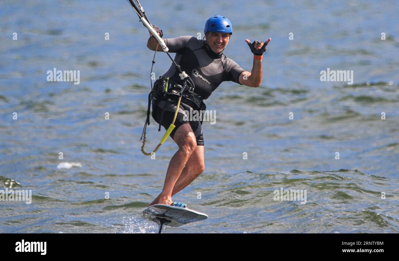 Gilgo Beach, New York, États-Unis - 13 août 2023 : Homme posant la signalisation se lâche avec sa main tout en kitesurf au large du coût de long Island. Banque D'Images