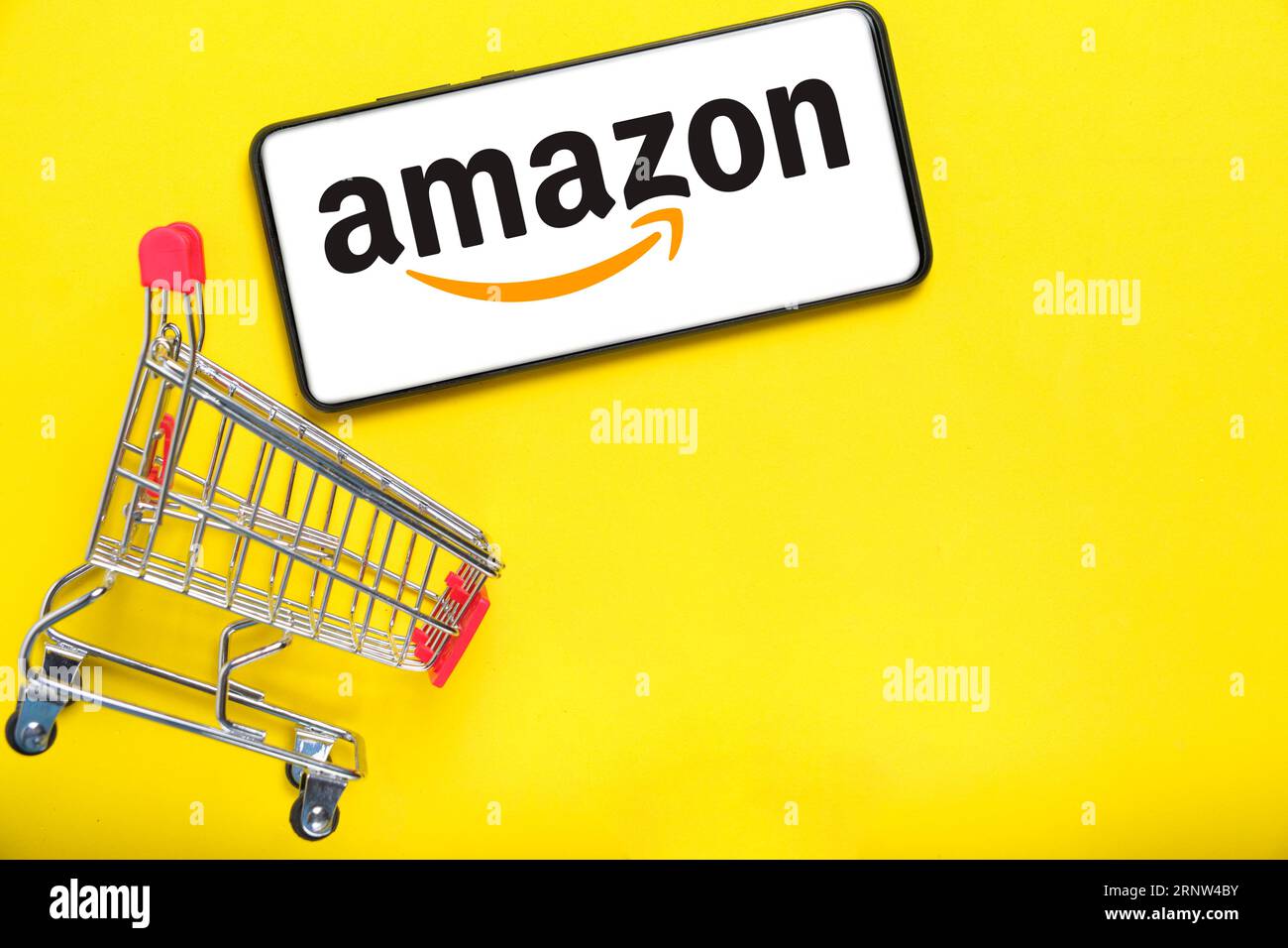 Kostanay, Kazakhstan, 31 août 2023. Smartphone avec logo amazon, panier jaune background.concept achats en ligne Banque D'Images