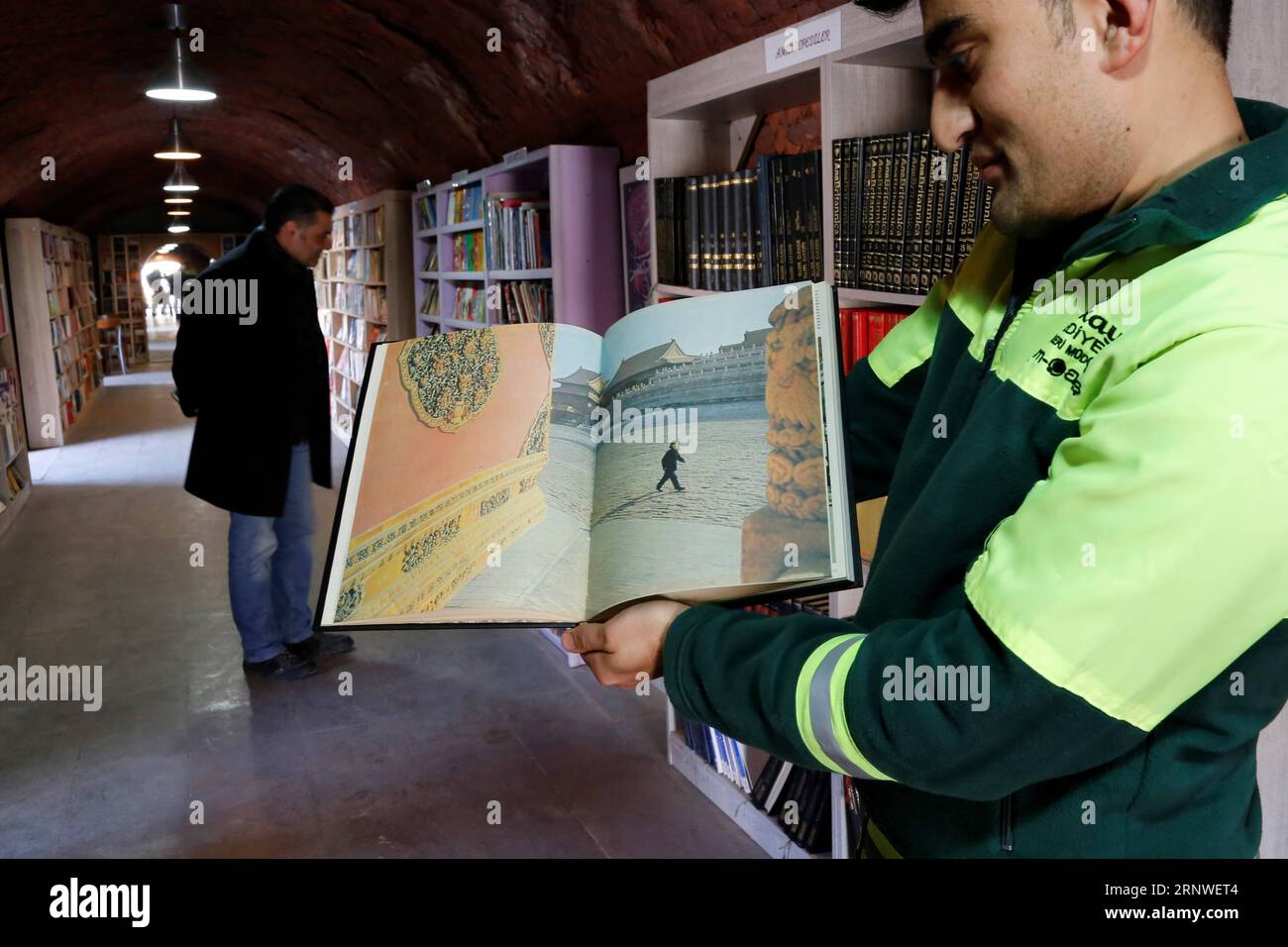 (171217) -- ANKARA, 17 décembre 2017 -- Un membre du personnel montre une photo de la Cité interdite dans une bibliothèque transformée d'une usine de briques abandonnée par la municipalité du district de Cankaya à Ankara, Turquie, 12 décembre 2017. Les vieux livres laissés dans les poubelles ont maintenant un nouveau bail sur la vie dans une usine de briques restaurée à Ankara en Turquie, où les collecteurs de déchets ont créé une bibliothèque unique ouverte à tous les visiteurs. (Zjl) TURQUIE-ANKARA-BIBLIOTHÈQUE-USINE DE BRIQUES QinxYanyang PUBLICATIONxNOTxINxCHN Banque D'Images