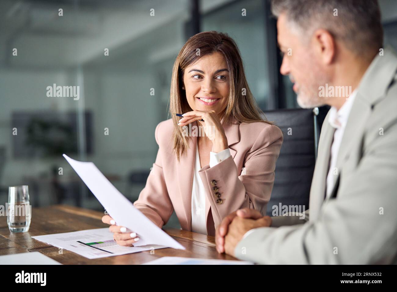 Deux dirigeants d'entreprise discutant des documents financiers au bureau lors de la réunion. Banque D'Images