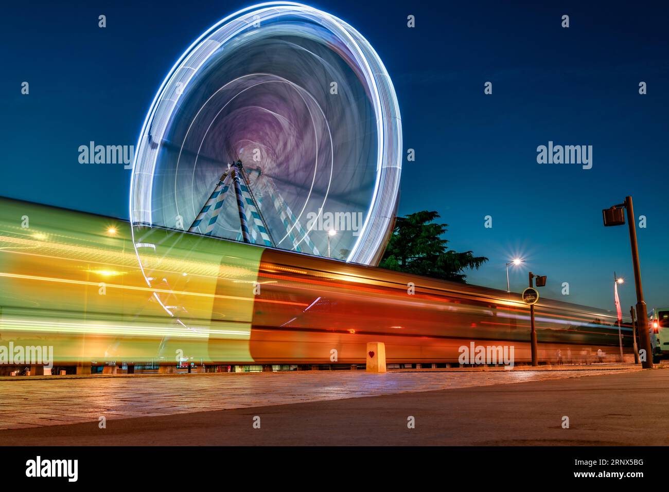 Feeris roue et tram traces de lumière dans les lumières du soir dans la ville de Tours, France Banque D'Images