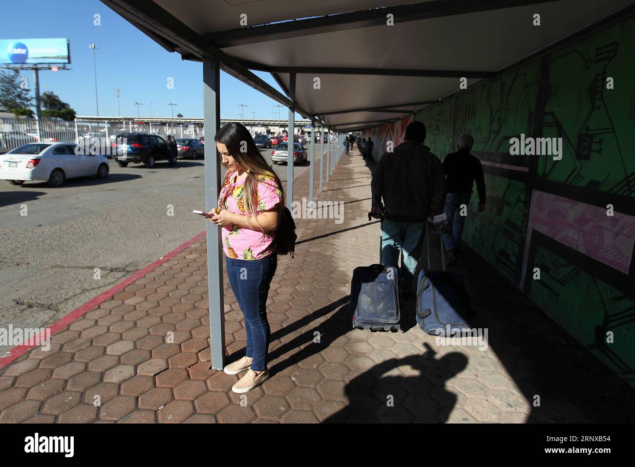 (180120) -- TIJUANA, 20 janvier 2018 -- Hazell Sepulveda envoie des messages à ses amis avant de traverser la frontière à Tijuana, Mexique, le 11 janvier 2018. Hazell Sepulveda, 26 ans, est née à San Diego de parents mexicains, et elle réside maintenant à Tijuana. Il lui faut cinq minutes pour traverser le point de passage d'Otay avant l'aube tous les jours avant de travailler à la cuisine d'un McDonald's à seulement 500 pas de la frontière. Une longue clôture bien gardée avec seulement trois portes divise les deux villes, un marché de 6,5 millions de personnes et une économie qui génère 230 milliards de dollars américains par an, selon Mexico s for Banque D'Images