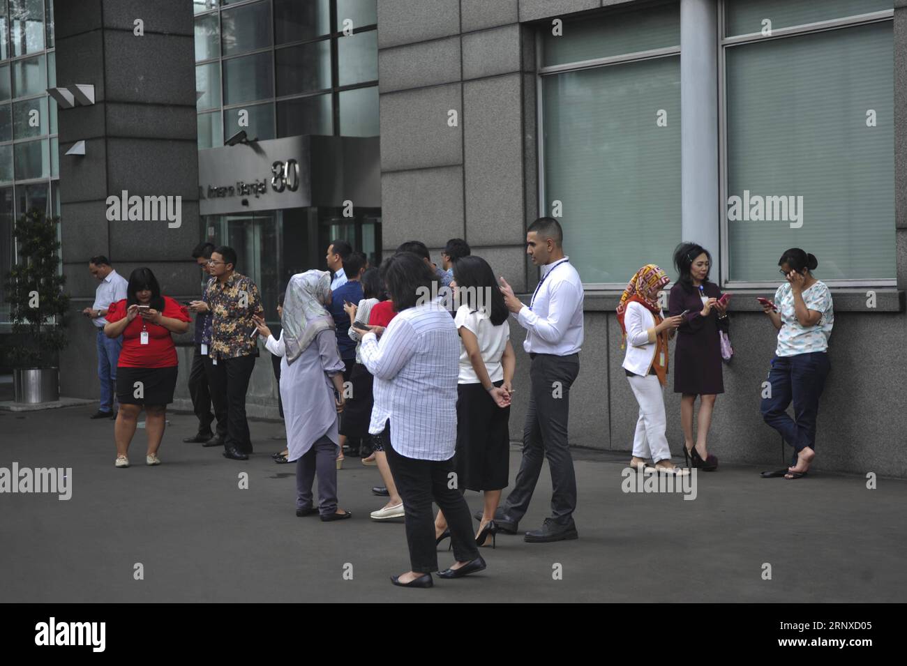 (180123) -- JAKARTA, 23 janvier 2018 -- des gens se rassemblent devant un bâtiment à Jakarta, Indonésie, janvier 23. 2018. Un tremblement de terre d ' une magnitude de 6,1 sur l ' échelle de Richter a secoué Jakarta mardi, mais il n ' y avait pas de risque de tsunami, a déclaré Dedi Sugianto, fonctionnaire de l ' agence de météorologie et de géophysique. (Whw) INDONÉSIE-JAKARTA-TREMBLEMENT DE TERRE Zulkarnain PUBLICATIONxNOTxINxCHN Banque D'Images