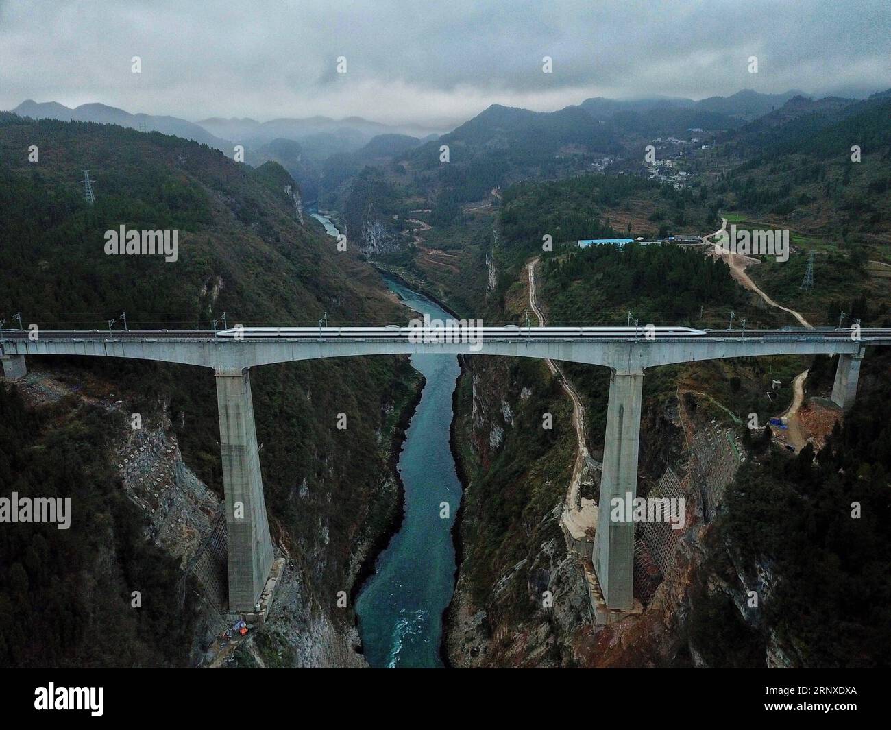 180125 -- GUIYANG, le 25 janvier 2018 -- Un train à grande vitesse traverse un pont sur le fleuve Wujiang, un affluent du fleuve le plus long de Chine, le Yangtze, sur la ligne Chongqing-Guiyang dans la ville de Zunyi, dans la province du Guizhou, au sud-ouest de la Chine, le 25 janvier 2018. Un chemin de fer reliant Chongqing et Guiyang, deux grandes villes du sud-ouest de la Chine, a commencé à fonctionner jeudi. Conçue pour les trains circulant à une vitesse de 200 km/h, la ligne ferroviaire de 347 km réduira le temps de trajet entre Chongqing et Guiyang de 10 heures à 2 heures, et raccourcira le temps de trajet entre Chengdu, capitale du Sichuan, et Guiyang Banque D'Images