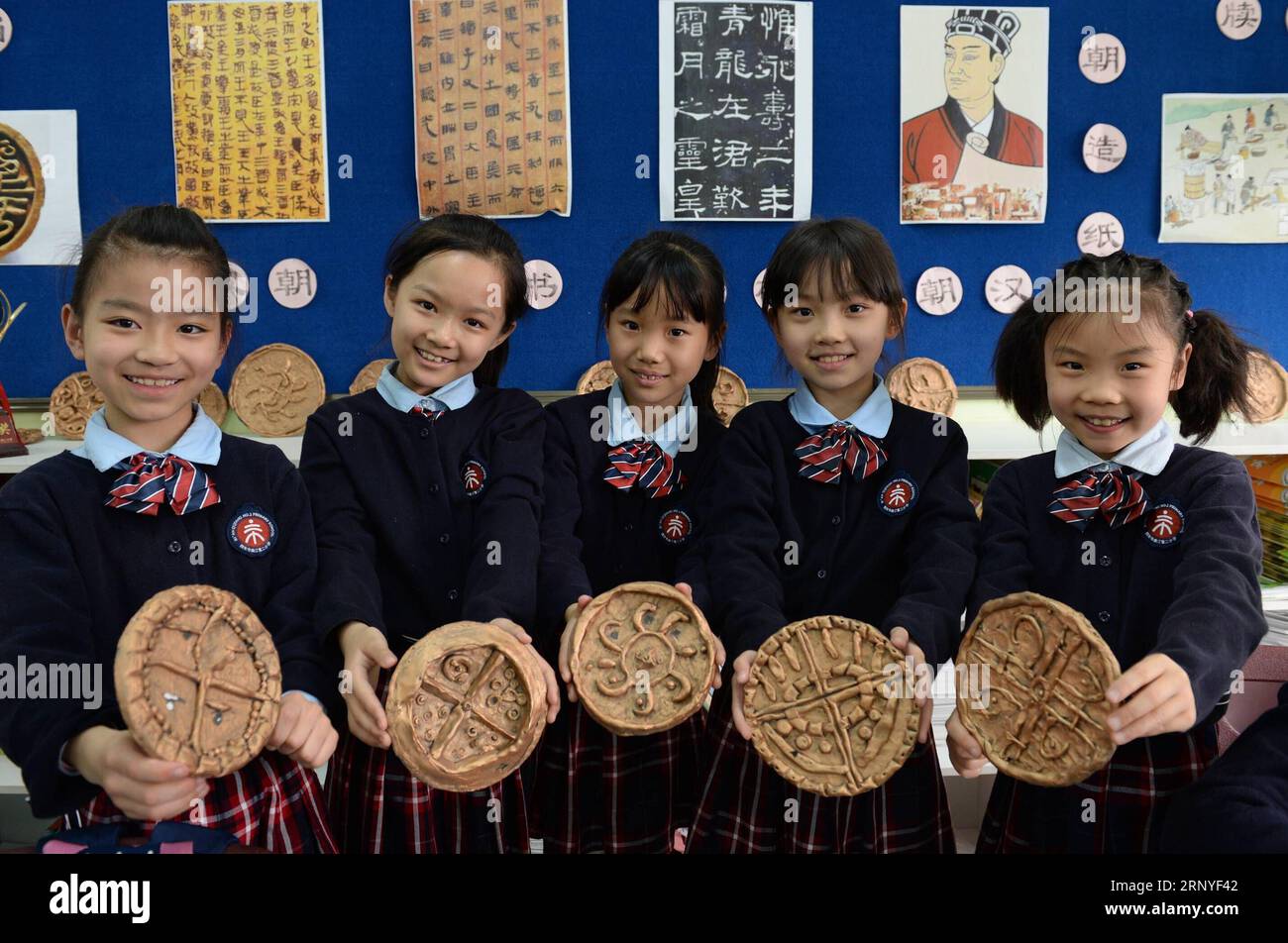 (180316) -- XI AN, 16 mars 2018 -- des étudiants montrent des répliques d'anciennes tuiles chinoises de gouttière qu'ils ont faites au cours d'une leçon d'études de musée à la deuxième école primaire de Qujiang à Xi an, dans la province du Shaanxi du nord-ouest de la Chine, le 15 mars 2018. En 2017, la deuxième école primaire de Qujiang à Xi an a commencé à introduire des contenus liés au musée dans son programme scolaire. Les étudiants apprendront sur les musées soit en classe, soit lors de visites d'étude. Récemment, l'école a même construit son propre musée de campus pour une meilleure expérience d'étude.) (lmm) CHINA-SHAANXI-PRIMARY SCHOOL-MUSEUM STUDIES (CN) LixYibo PUBLICATIONxNOTxINxCHN Banque D'Images