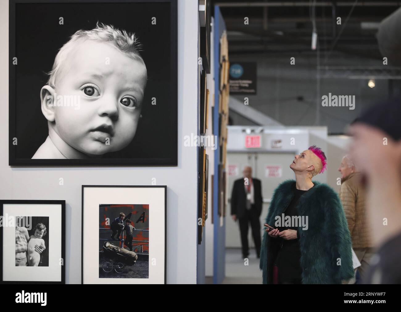 (180405) -- NEW YORK, 5 avril 2018 -- les visiteurs regardent les œuvres photographiques de l'exposition spéciale Forever Young à l'AIPAD (Association of International Photography Art Dealers) au salon de la photographie de New York, aux États-Unis, le 5 avril 2018. La 38e édition du salon de la photographie se tient du 5 au 8 avril. Environ 100 des plus grandes galeries de photographie artistique au monde présentent une gamme de travaux de qualité muséale, y compris des photographies contemporaines, modernes et du 19e siècle, ainsi que de l'art photographique, de la vidéo et des nouveaux médias. U.S.-NEW YORK-AIPAD-LE SPECTACLE DE WANGXYING PUBLIC Banque D'Images