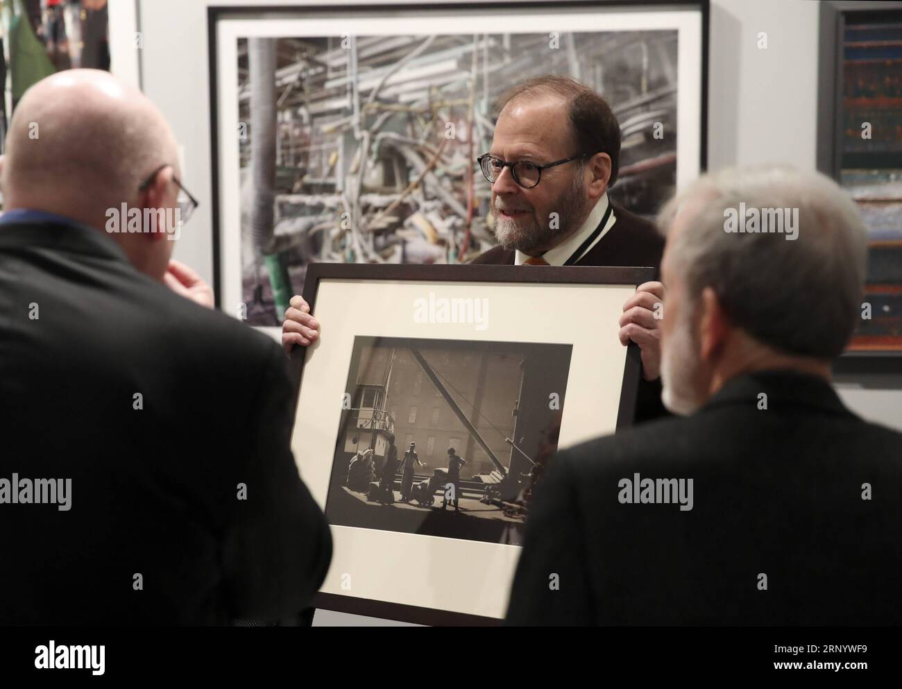 (180405) -- NEW YORK, le 5 avril 2018 -- un représentant de l'exposant (C) présente une œuvre photographique aux visiteurs au salon de photographie de l'AIPAD (Association of International Photography Art Dealers) à New York, aux États-Unis, le 5 avril 2018. La 38e édition du salon de la photographie se tient du 5 au 8 avril. Environ 100 des plus grandes galeries de photographie artistique au monde présentent une gamme de travaux de qualité muséale, y compris des photographies contemporaines, modernes et du 19e siècle, ainsi que de l'art photographique, de la vidéo et des nouveaux médias. U.S.-NEW YORK-AIPAD-LE PUB WANGXYING EST EXPOSÉ À LA PHOTOGRAPHIE Banque D'Images