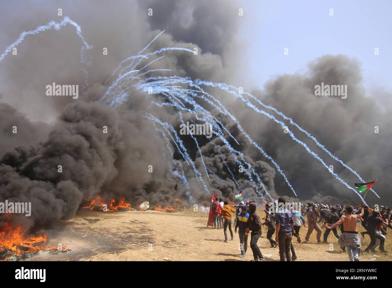 (180406) -- GAZA, 6 avril 2018 -- des manifestants palestiniens courent pour se couvrir contre des bombes lacrymogènes tirées par les troupes israéliennes lors d'affrontements à la frontière Gaza-Israël, à l'est de la ville de Gaza, le 6 avril 2018. Des centaines de manifestants palestiniens ont commencé vendredi à mettre le feu à des dizaines de pneus de voiture près de la frontière entre l'est de la bande de Gaza et Israël dans le but de faire un bouclier de fumée noire pour se protéger des tirs des soldats israéliens. zf) MIDEAST-GAZA-AFFRONTEMENTS KhaledxOmar PUBLICATIONxNOTxINxCHN Banque D'Images