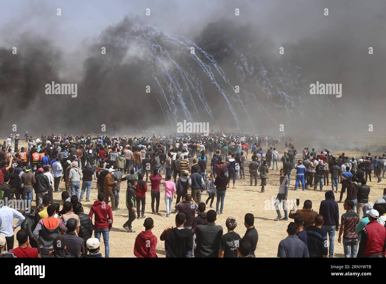 (180406) -- GAZA, 6 avril 2018 -- des manifestants palestiniens courent pour se couvrir contre des bombes lacrymogènes tirées par les troupes israéliennes lors d'affrontements à la frontière Gaza-Israël, à l'est de la ville de Gaza, le 6 avril 2018. Des centaines de manifestants palestiniens ont commencé vendredi à mettre le feu à des dizaines de pneus de voiture près de la frontière entre l'est de la bande de Gaza et Israël dans le but de faire un bouclier de fumée noire pour se protéger des tirs des soldats israéliens. zf) MIDEAST-GAZA-AFFRONTEMENTS KhaledxOmar PUBLICATIONxNOTxINxCHN Banque D'Images