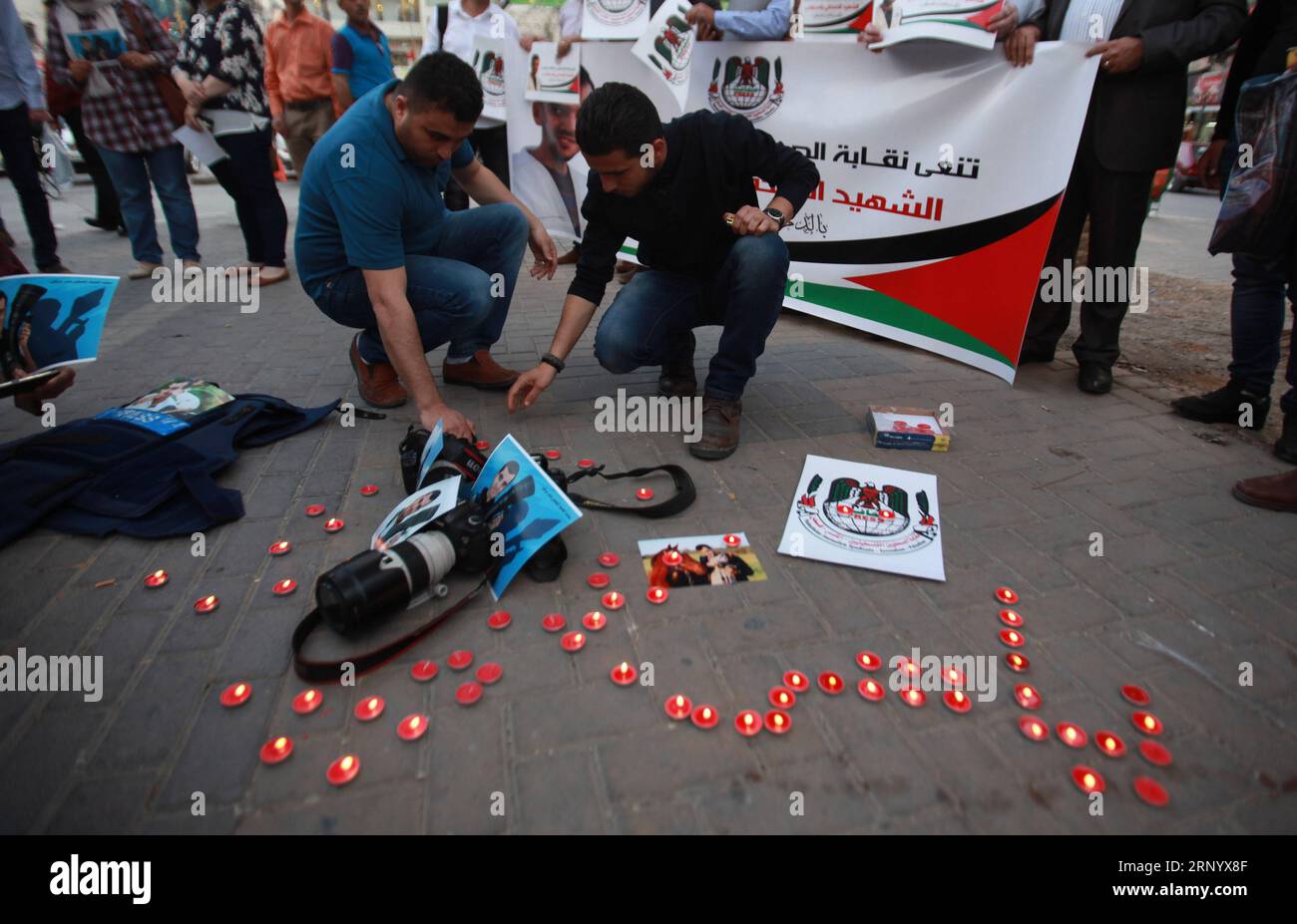 (180407) -- NAPLOUSE, 7 avril 2018 -- des journalistes palestiniens allument des bougies autour de photos du journaliste palestinien Yasser Murtaga dans la ville de Naplouse, en Cisjordanie, le 7 avril 2018. Yasser Murtaga, journaliste de 30 ans, couvrait les manifestations à l'est de Khan Younis lorsqu'il a été abattu et est mort plus tard de sa blessure. MIDEAST-NAPLOUSE-GAZA RASSEMBLEMENT-JOURNALISTE-MORT-DEUIL NIDALXESHTAYEH PUBLICATIONXNOTXINXCHN Banque D'Images