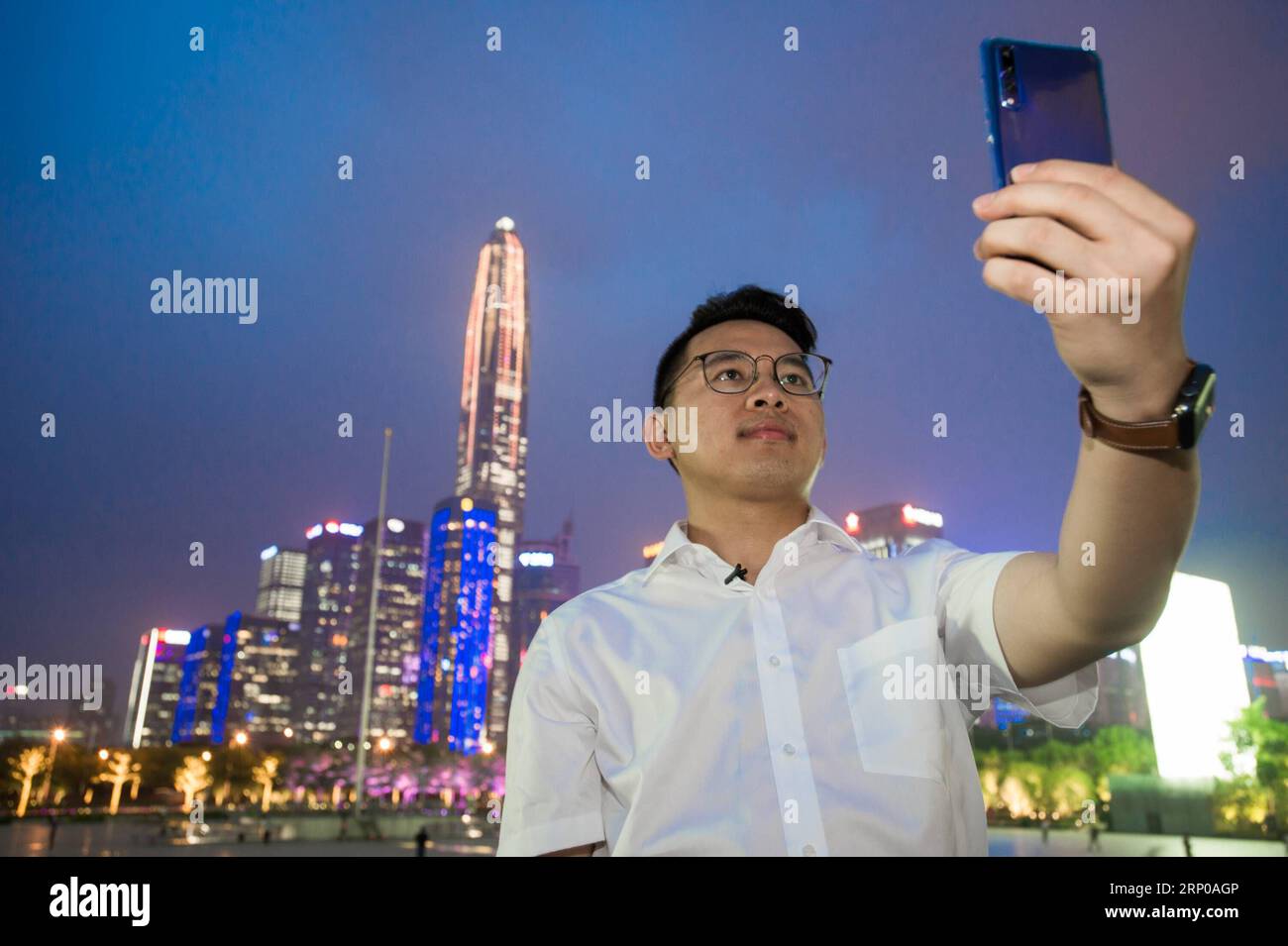 (180430) -- SHENZHEN, 30 avril 2018 -- le décorateur d'intérieur Huang Songyuan prend un selfie avec des gratte-ciel à Shenzhen, dans la province du Guangdong du sud de la Chine, le 27 avril 2018. En quatre décennies, depuis que la Chine a entrepris la réforme et la politique d'ouverture, Shenzhen s'est transformée d'une petite ville agricole en une métropole moderne en plein essor. En tant que première zone économique spéciale de la Chine, la ville a réussi à réaliser des progrès en matière de développement car elle se développe rapidement à l avant-poste de la réforme économique du pays. Aujourd'hui s Shenzhen est à première main une ville de merveilles architecturales et d'ingénierie. Derrière ses s ascendants Banque D'Images
