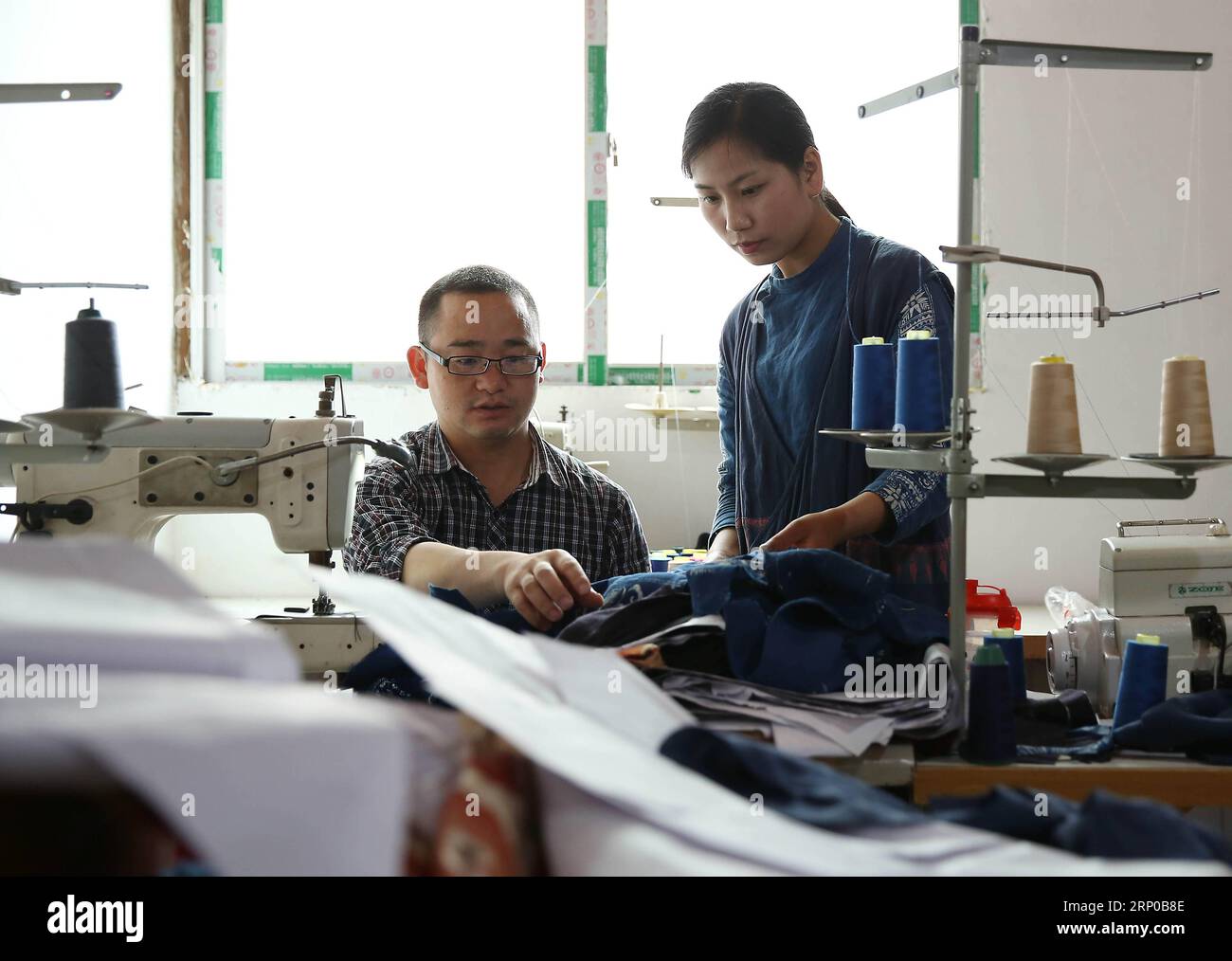 (180503) -- DANZHAI, 3 mai 2018 -- Zhang Yiping (à droite) discute de la production de vêtements batik avec son collègue dans le comté de Danzhai, dans la province du Guizhou du sud-ouest de la Chine, le 2 mai 2018. Obsédée par la culture batik depuis un enfant, Zhang Yiping, une jeune femme née en 1993, a démarré sa propre entreprise de créations batik dans sa ville natale de Danzhai en 2014. Grâce à plusieurs années de développement, Zhang a mis en place son magasin de batik et aussi une base de production artisanale où plus de 100 femmes locales étaient employées.) (Sxk) (zt) CHINA-GUIZHOU-DANZHAI-ENTREPRENEUR STORY (CN) HuangxXiaohai PUBLICATIONxNOTxINxCHN Banque D'Images