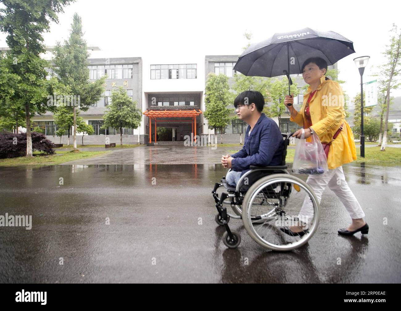 (180510) -- BEICHUAN, 10 mai 2018 -- Zheng Haiyang, survivant qui a perdu ses jambes dans le tremblement de terre de magnitude 8,0 de Wenchuan en 2008, est assis sur un fauteuil roulant et est aidé par sa mère pour visiter la nouvelle école secondaire Beichuan dans le comté de Beichuan, dans la province du Sichuan au sud-ouest de la Chine, le 8 mai 2018. Il y a dix ans, Zheng, alors élève de 17 ans à l’école secondaire de Beichuan, a été extirpé 22 heures après avoir été pris au piège dans les décombres du bâtiment de l’école dans le comté de Beichuan. Beichuan a été l'une des régions les plus touchées lorsque le séisme catastrophique a frappé le comté de Wenchuan le 12 mai 2008. Zheng était un Banque D'Images