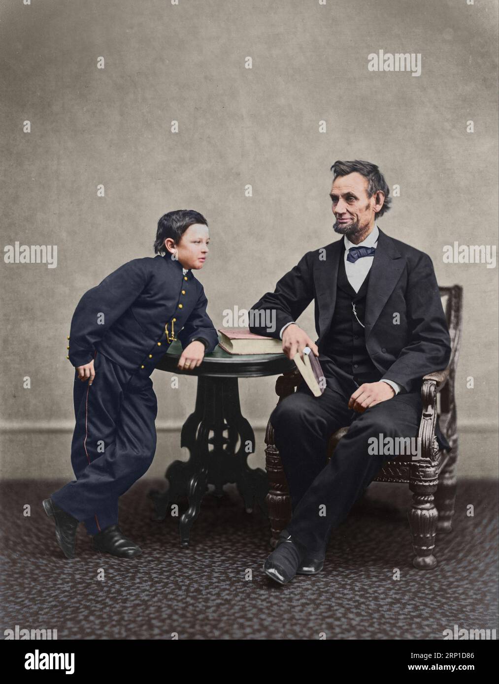Abraham Lincoln, assis et tenant un livre, avec son fils Tad (Thomas) appuyé sur une table. 5 février 1865. Photographe : Alexander Gardner. Prise au Gard Banque D'Images