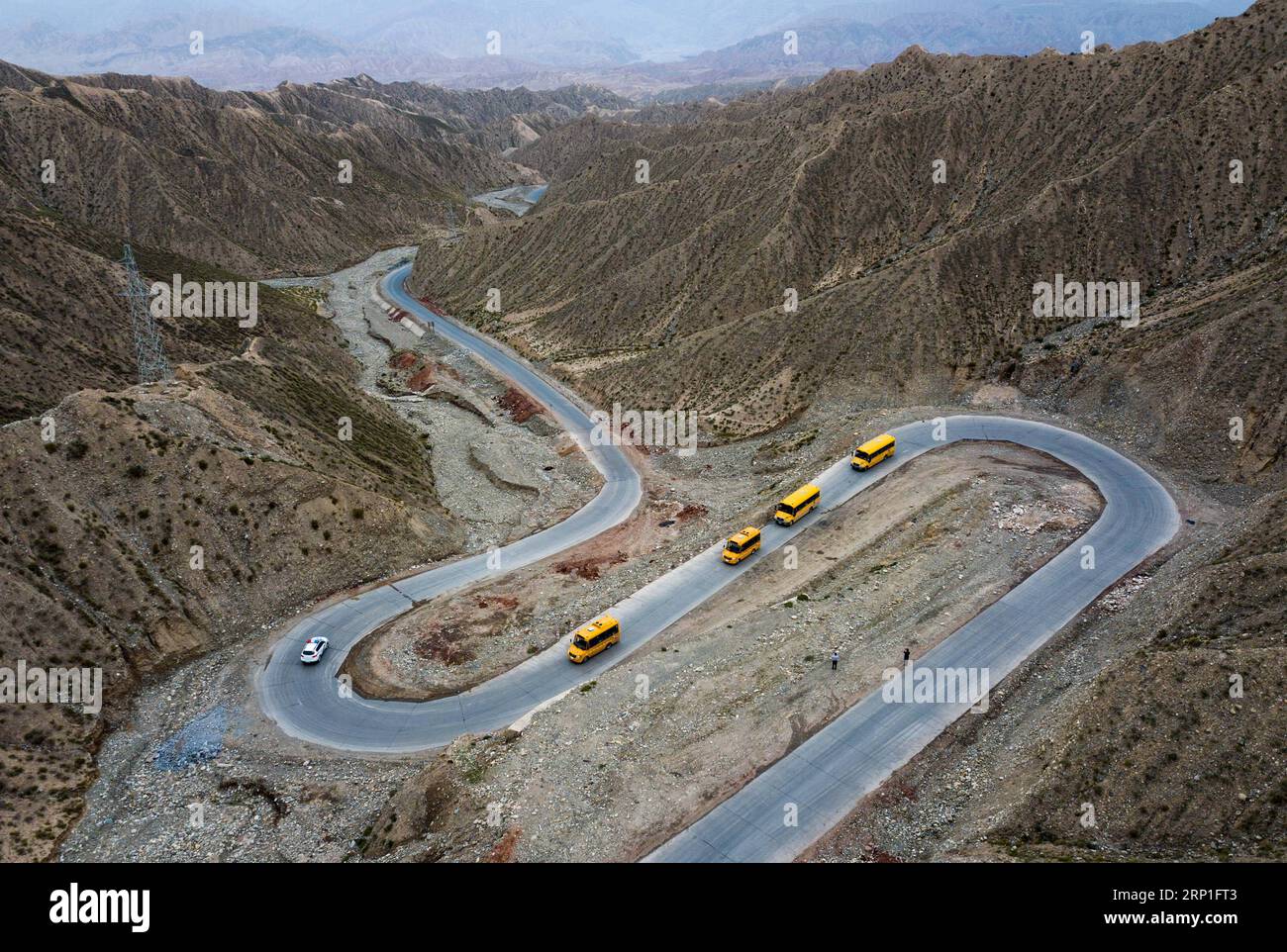 (180704) -- AKTO, 4 juillet 2018 -- des autobus scolaires transportant des élèves roulent sur une route menant à leur domicile dans le comté d'Akto, dans la région autonome ouïgoure du Xinjiang, au nord-ouest de la Chine, 2 juillet 2018. Comme les vacances d'été arrivent, le comté organise des autobus scolaires escortés par la voiture de police pour aider les plus de 2 000 étudiants, qui étudient dans le siège du comté, de retour à la maison dans les zones agricoles et d'élevage en toute sécurité.) (Sxk) CHINA-XINJIANG-AKTO-STUDENT (CN) JiangxWenyao PUBLICATIONxNOTxINxCHN Banque D'Images