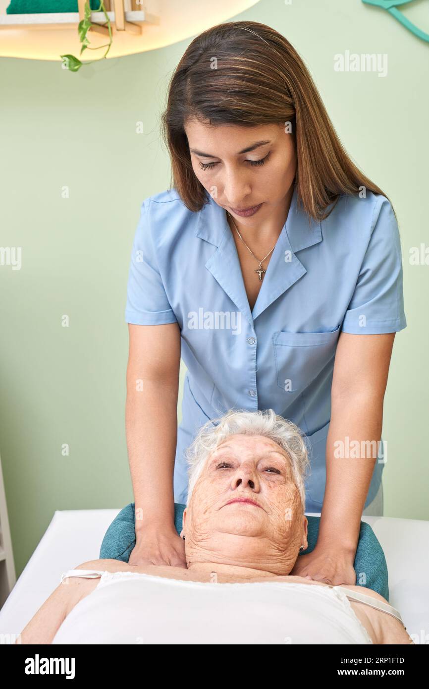 Médecin exerçant une pression sur le dos d'une femme âgée Banque D'Images