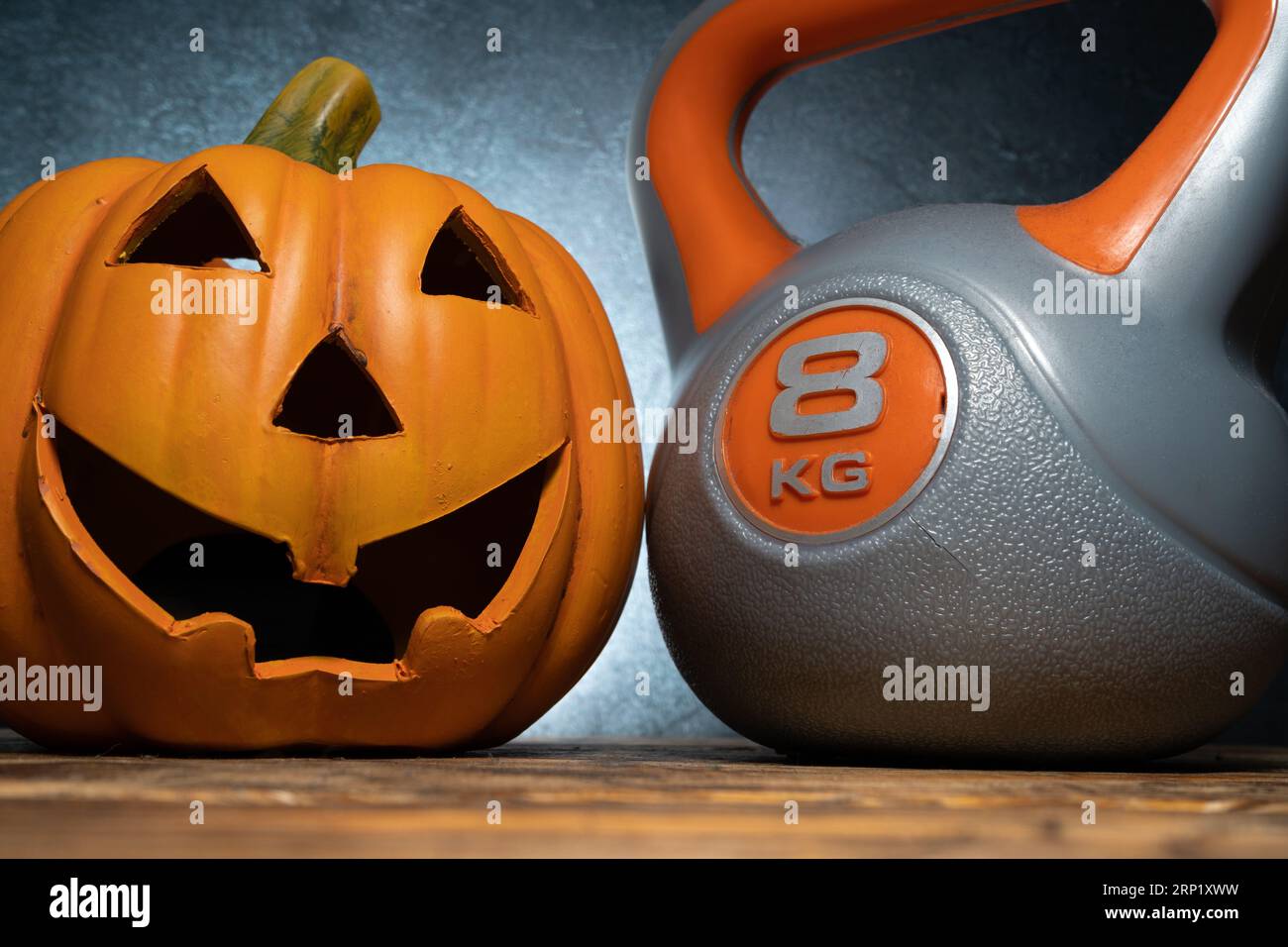 Décoration de citrouille d'Halloween et équipement d'exercice de kettlebell. Composition effrayante d'automne de fitness sain. Entraînement de gym, concept d'entraînement sportif. Banque D'Images