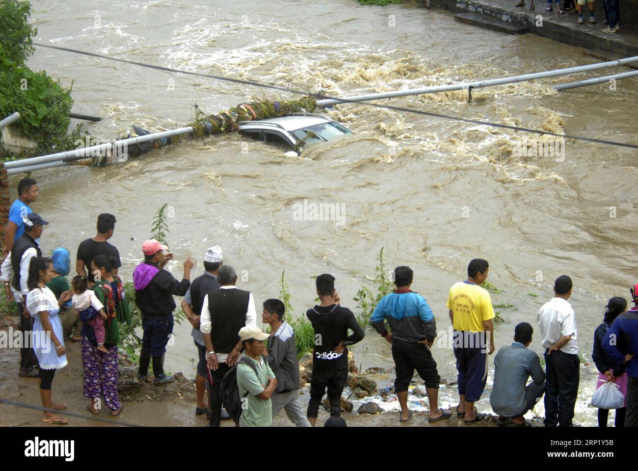 (180806) -- LALITPUR, 6 août 2018 -- des gens regardent une voiture noyée emportée par la rivière Godawari gonflée à la suite de pluies torrentielles à Lalitpur, Népal, le 6 août 2018.) (Jmmn) NÉPAL-LALITPUR-PLUIE TORRENTIELLE SunilxSharma PUBLICATIONxNOTxINxCHN Banque D'Images