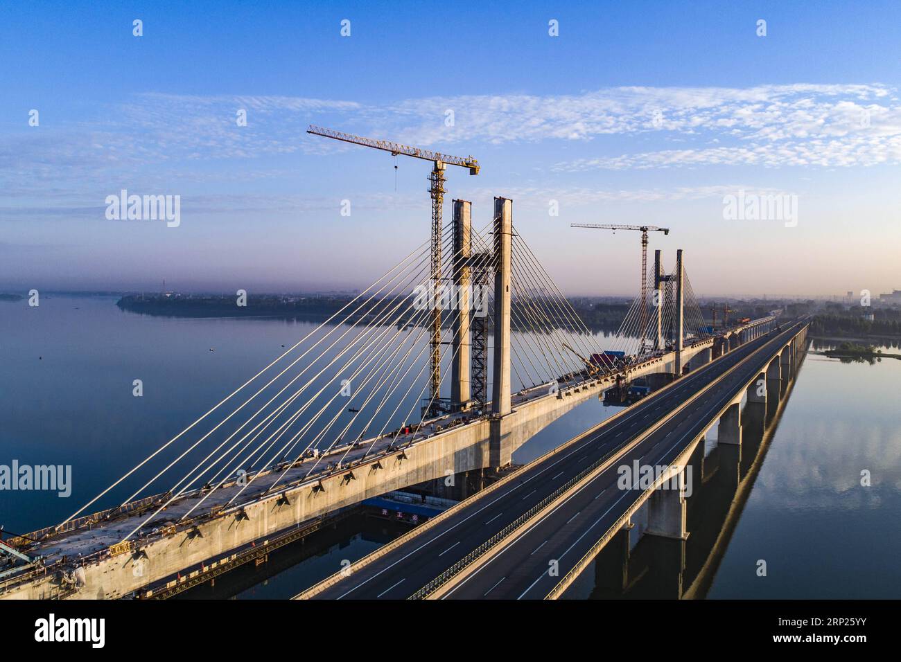 (180820) -- XIANGYANG, 20 août 2018 (Xinhua) -- une photo aérienne prise le 20 août 2018 montre le chantier de construction du pont Hanjiang du chemin de fer de Menghua traversant la rivière Hanjiang dans la ville de Xiangyang, dans la province du Hubei en Chine centrale. Le pont Hanjiang du chemin de fer de Menghua a terminé son installation de câbles lundi. Le grand pont de 5 242 mètres est une partie importante du chemin de fer de Menghua, une route stratégique de transport du charbon de 1 817 kilomètres reliant la région autonome de Mongolie intérieure, riche en charbon du nord de la Chine, au centre et au sud de la Chine. (Xinhua/Jin Wei) (hxy) CHINA-HUBEI-RAILWAY-CONSTRUCTION (CN Banque D'Images