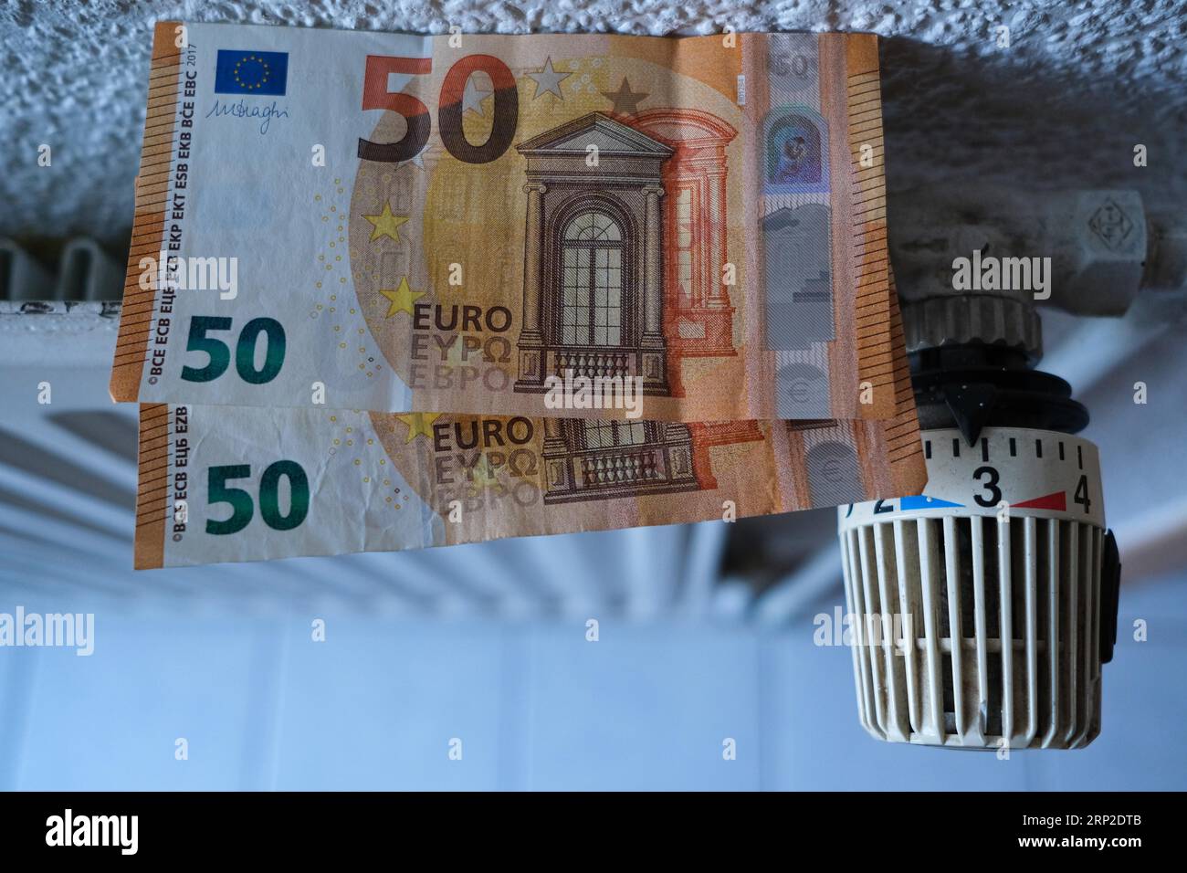 Photo symbolique sur le thème des frais de chauffage, billets de 50 euros sur un radiateur, Rhénanie du Nord-Westphalie, Allemagne Banque D'Images
