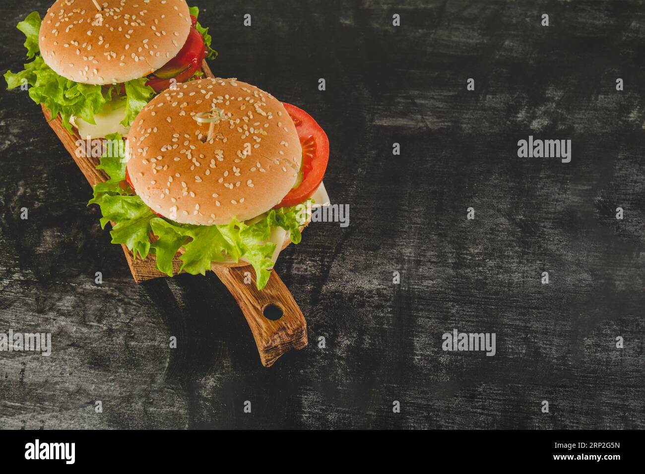 Surface sombre avec de délicieux hamburgers Banque D'Images Surface sombre avec de délicieux hamburgers Banque D'Images