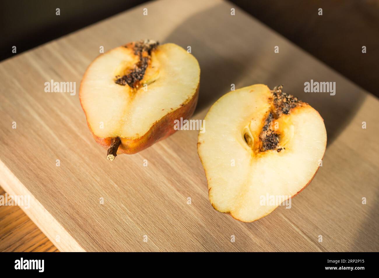 Poires endommagées sur la table en bois. Poires avec ver sur la planche à découper. Fruits juteux. Agriculture d'automne. Récolte d'automne. Nourriture crue. Tranches de poire douce. Banque D'Images