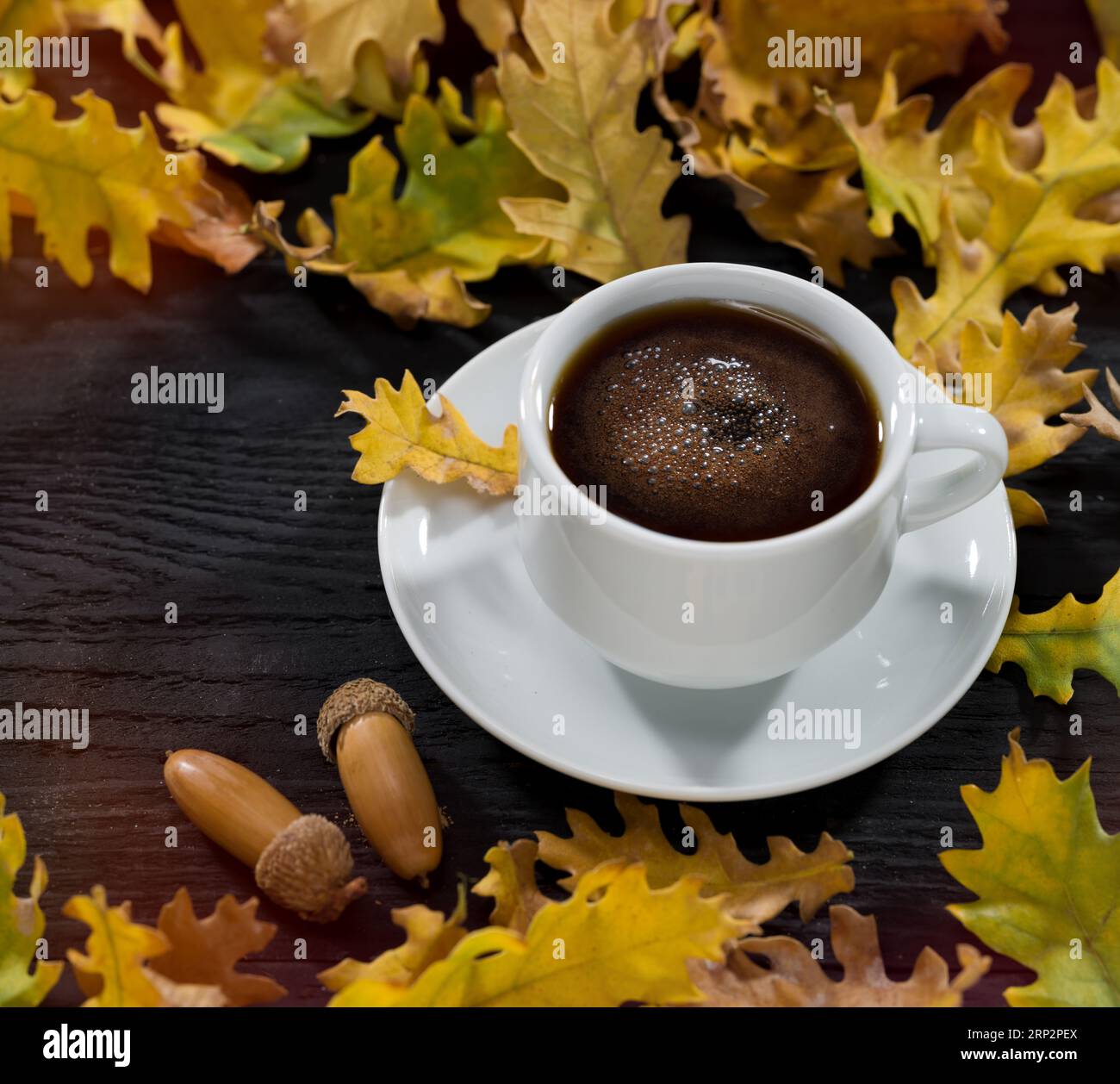 Feuilles d'automne sur la table et café mousseux chaud. L'heure du café en automne Banque D'Images