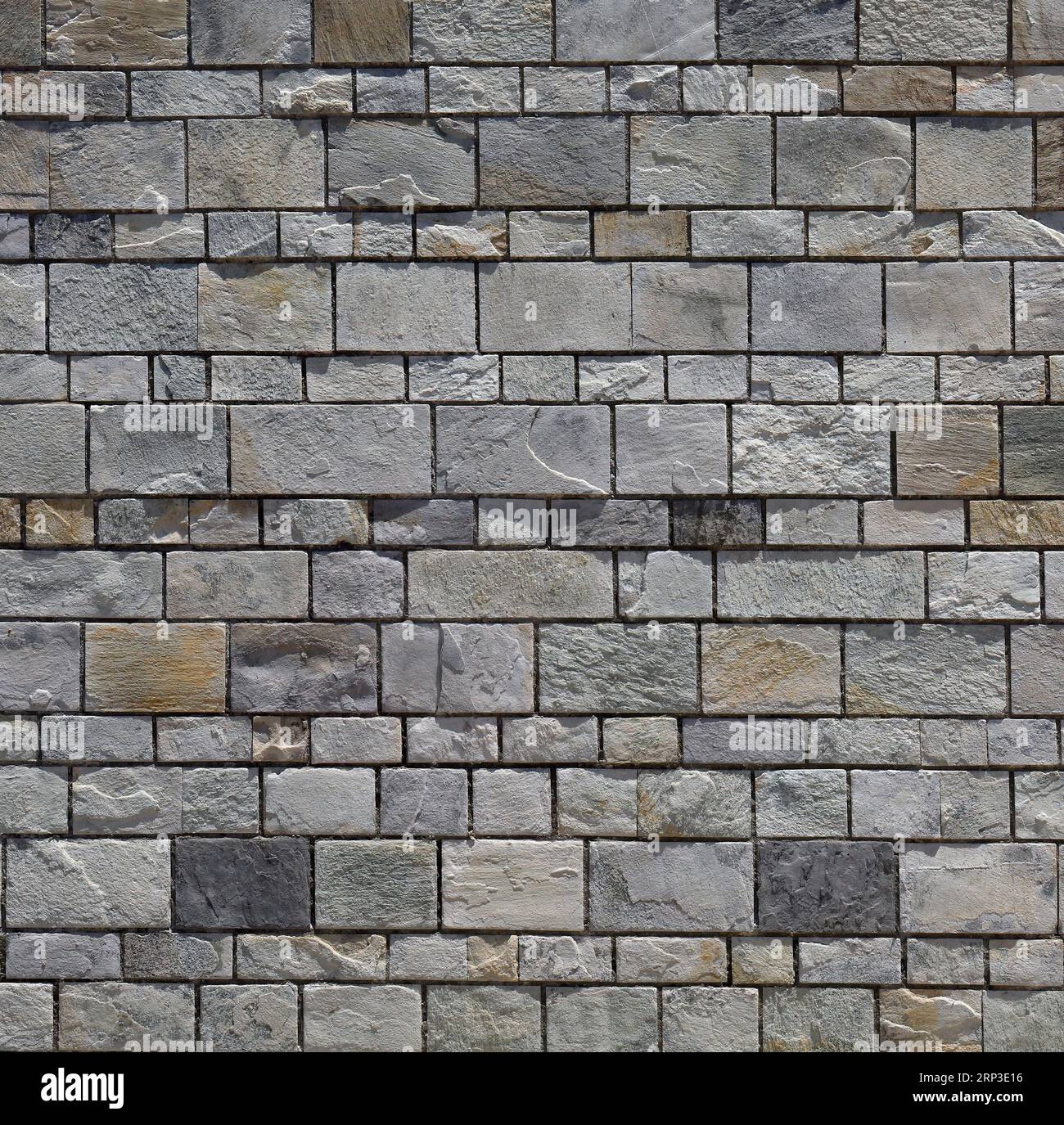 Mur de pierre / mur de briques - blocs gris uniformément espacés. Banque D'Images