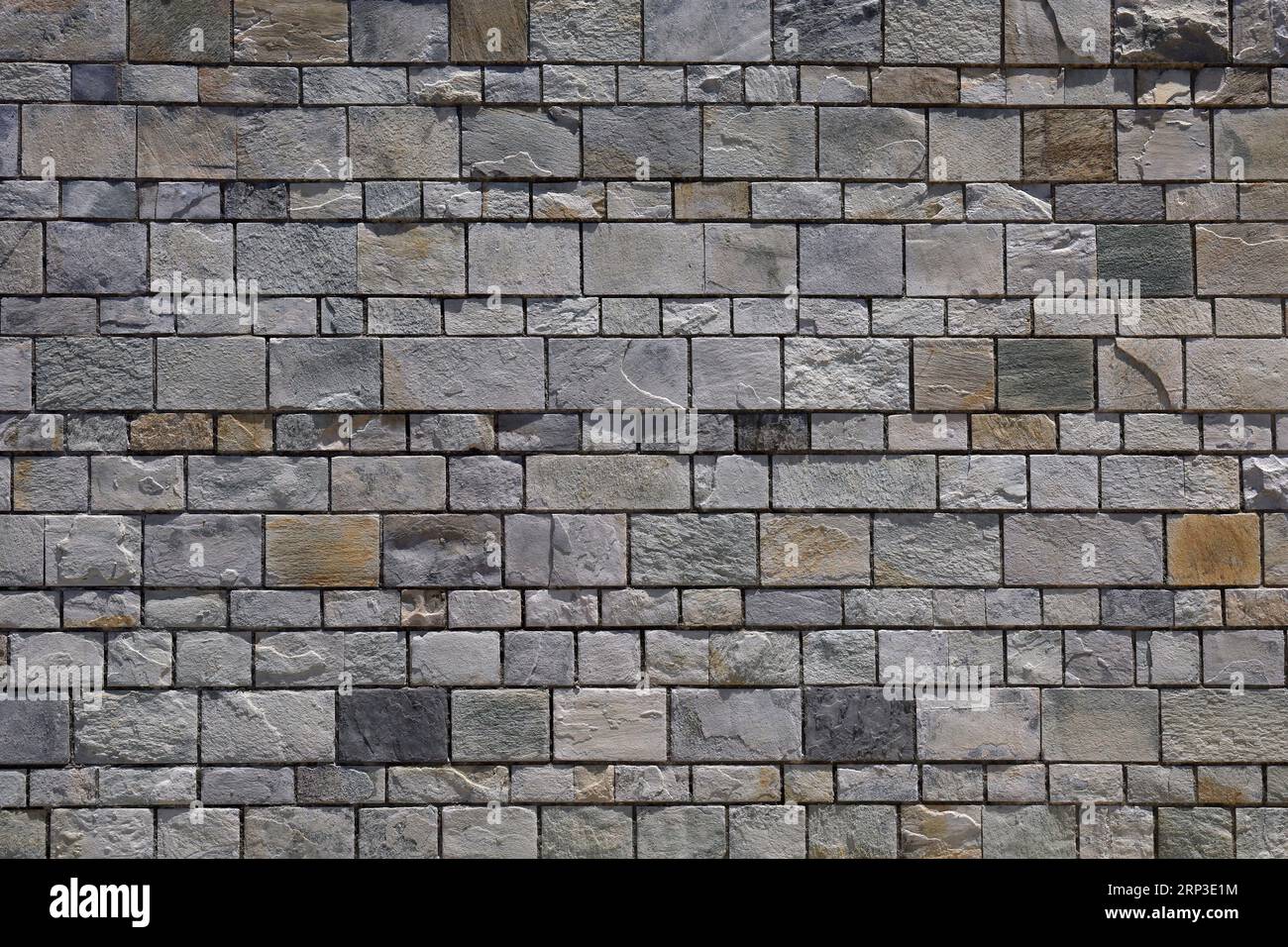 Mur de pierre / mur de briques - blocs gris uniformément espacés. Banque D'Images