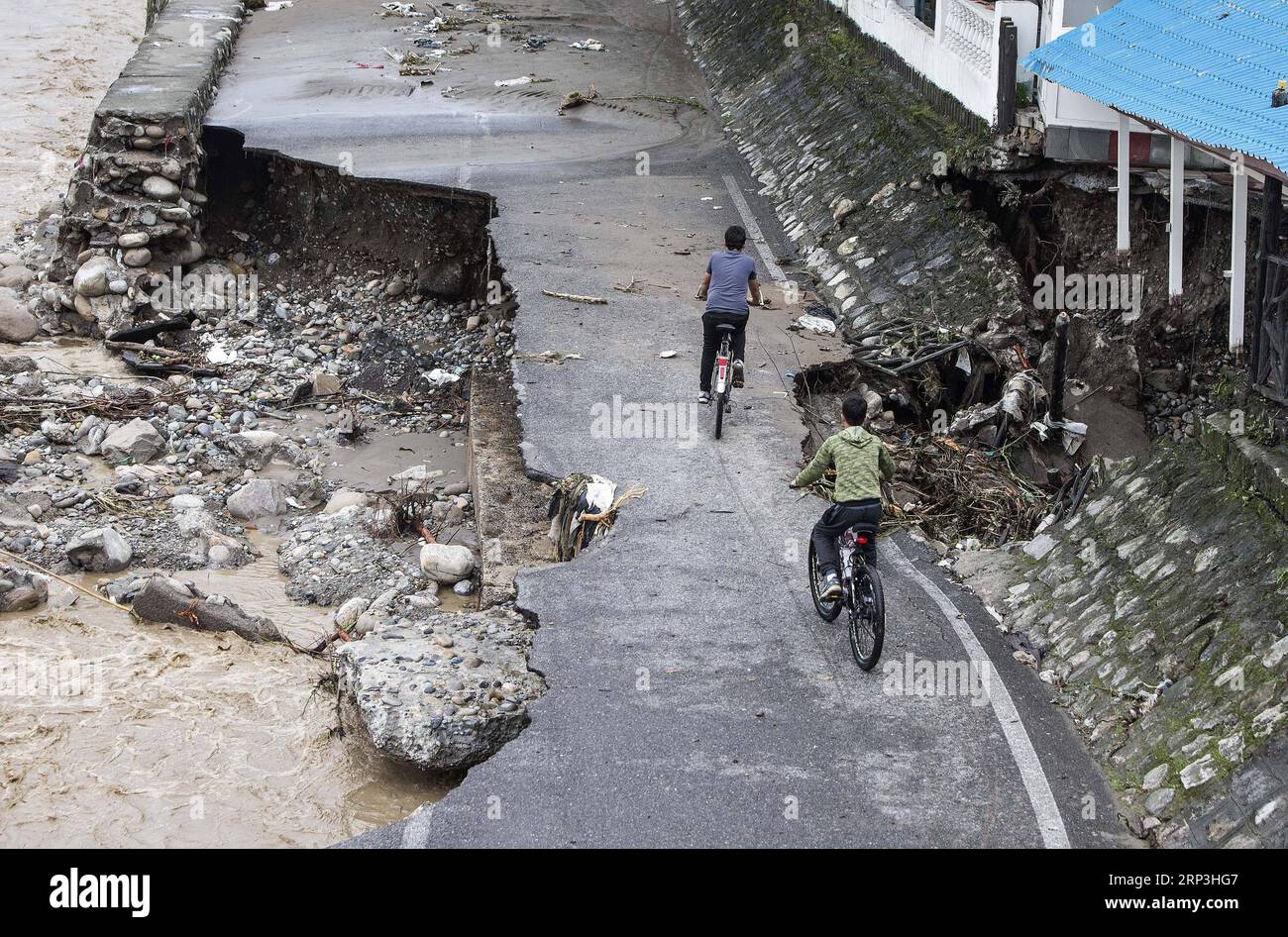 (181007) -- TONEKABON, 7 octobre 2018 -- des personnes roulent à vélo sur une route détruite après une inondation causée par de fortes pluies dans la ville de Tonekabon, dans la province de Mazandaran, au nord de l'Iran, le 6 octobre 2018. Les fortes pluies dans les régions nord et nord-ouest de l'Iran au cours des deux derniers jours ont coûté la vie à au moins sept personnes, a rapporté samedi l'agence de presse semi-officielle ISNA. (dtf) IRAN-TONEKABON-FLOOD AhmadxHalabisaz PUBLICATIONxNOTxINxCHN Banque D'Images