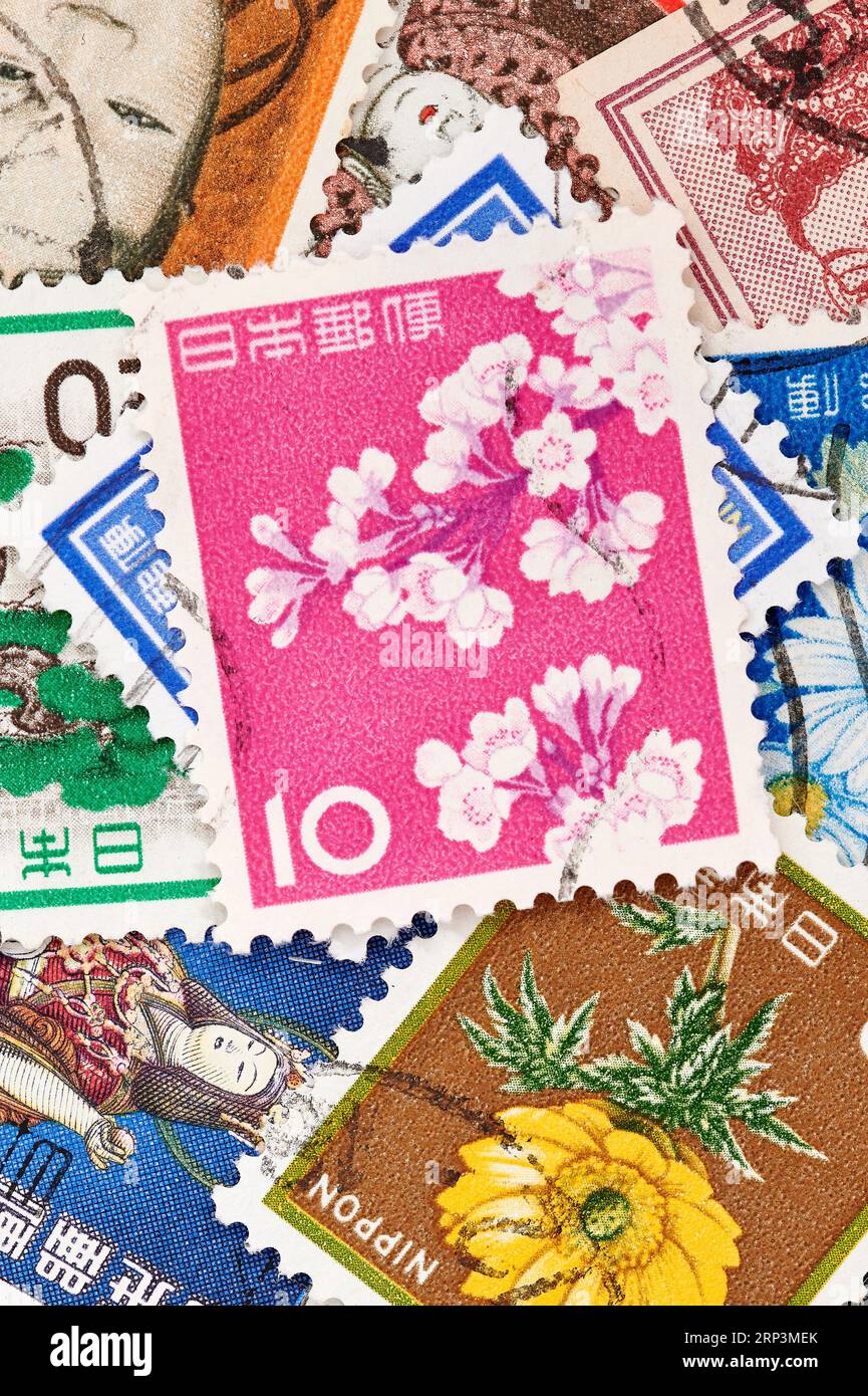 Madrid, Espagne ; 08-13-2023, timbre-poste du Japon avec des fleurs de cerisier sur fond rose avec plus de timbres formant un fond Banque D'Images