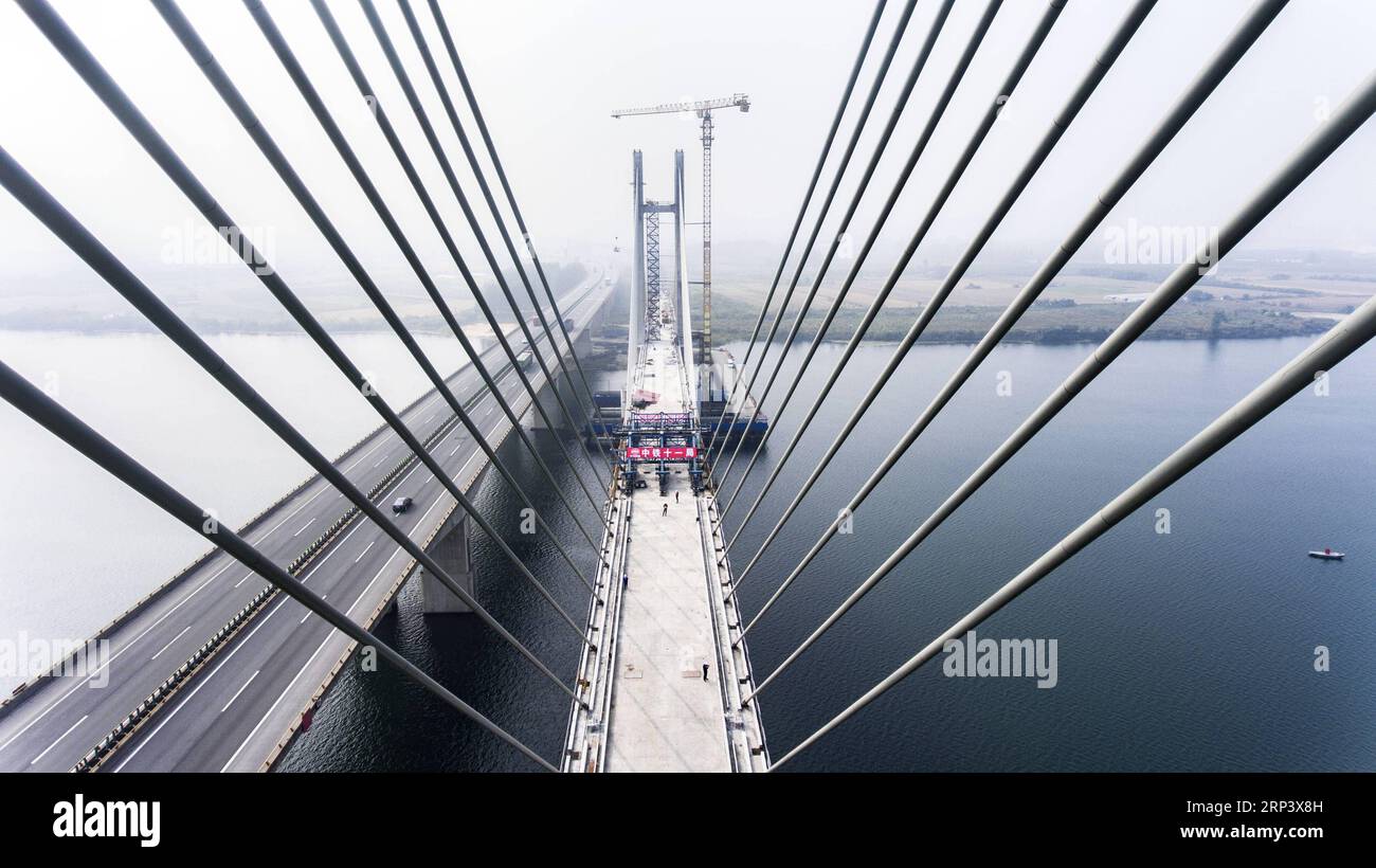 (181018) -- XIANGYANG, 18 octobre 2018 (Xinhua) -- une photo aérienne prise le 18 octobre 2018 montre le site de construction du pont Hanjiang du chemin de fer Menghua traversant la rivière Hanjiang dans la ville de Xiangyang, dans la province du Hubei, au centre de la Chine. La fermeture de la section principale du pont Hanjiang a été achevée jeudi. Le chemin de fer de Menghua est une voie de transport du charbon de 1 817 kilomètres reliant la région autonome de Mongolie intérieure, riche en charbon du nord de la Chine, au centre et au sud de la Chine. (Xinhua/Jin Wei)(sxk) CHINA-HUBEI-RAILWAY-CONSTRUCTION (CN) PUBLICATIONxNOTxINxCHN Banque D'Images