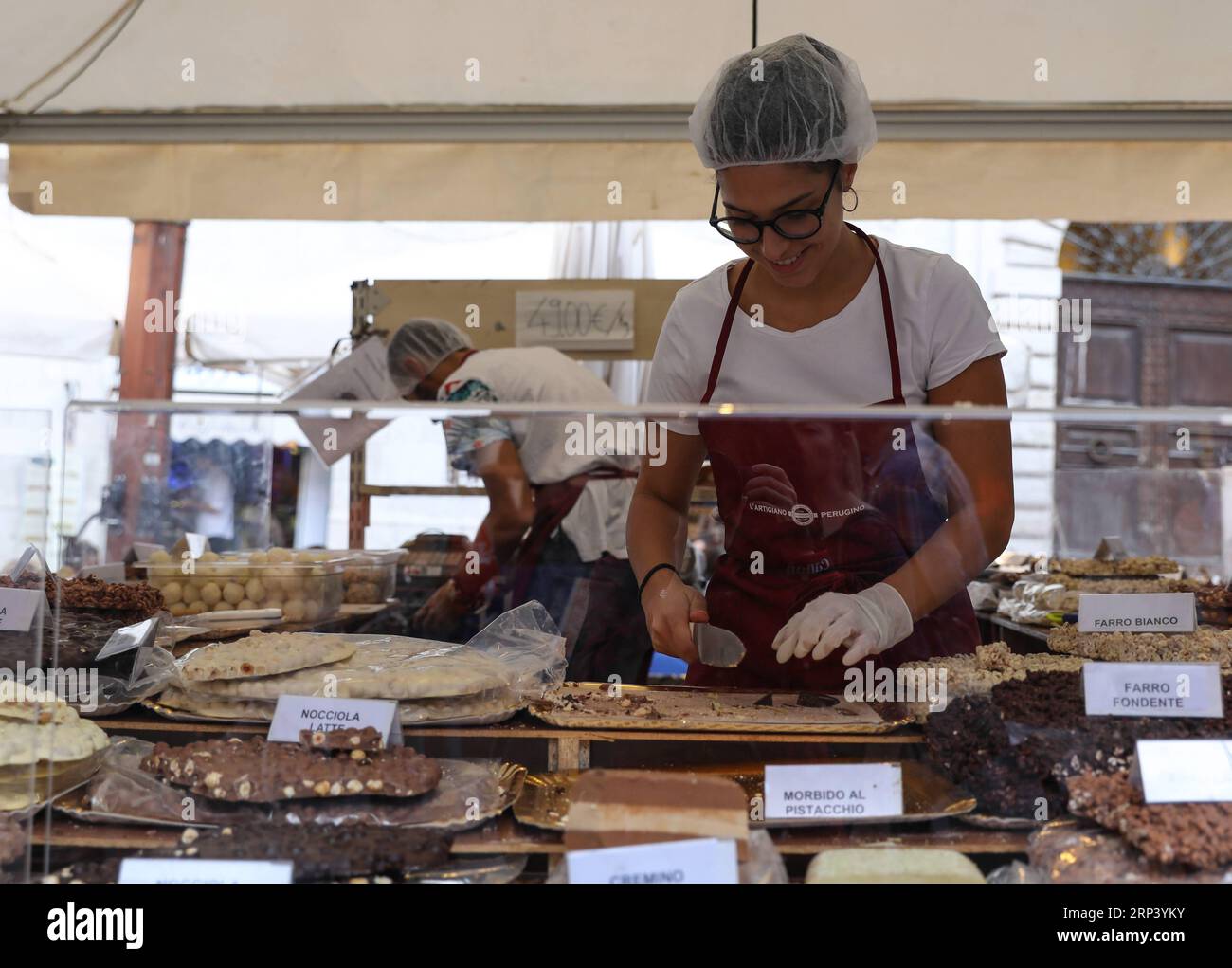 (181019) -- PÉROUSE (ITALIE), 19 octobre 2018 -- un travailleur coupe du chocolat lors du 25e Eurochocolate à Pérouse, Italie, le 19 octobre 2018. Le 25e festival international du chocolat Eurochocolate a débuté vendredi à Pérouse, une ville italienne avec une tradition de production de chocolat. Le festival annuel offrait une variété d'activités, y compris des expositions d'art de chocolat, des dégustations de chocolat, des spectacles de rue et des sculptures de chocolat.) ITALIE-PERUGIA-EUROCHOCOLATE ChengxTingting PUBLICATIONxNOTxINxCHN Banque D'Images