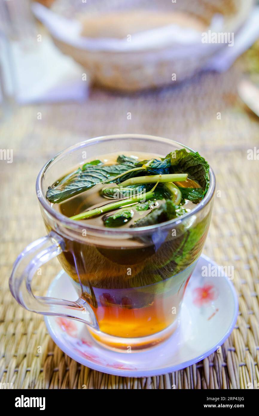 Gros plan d'un verre de thé à la menthe marocain posé sur la table à manger dans un restaurant à Marrakech Banque D'Images